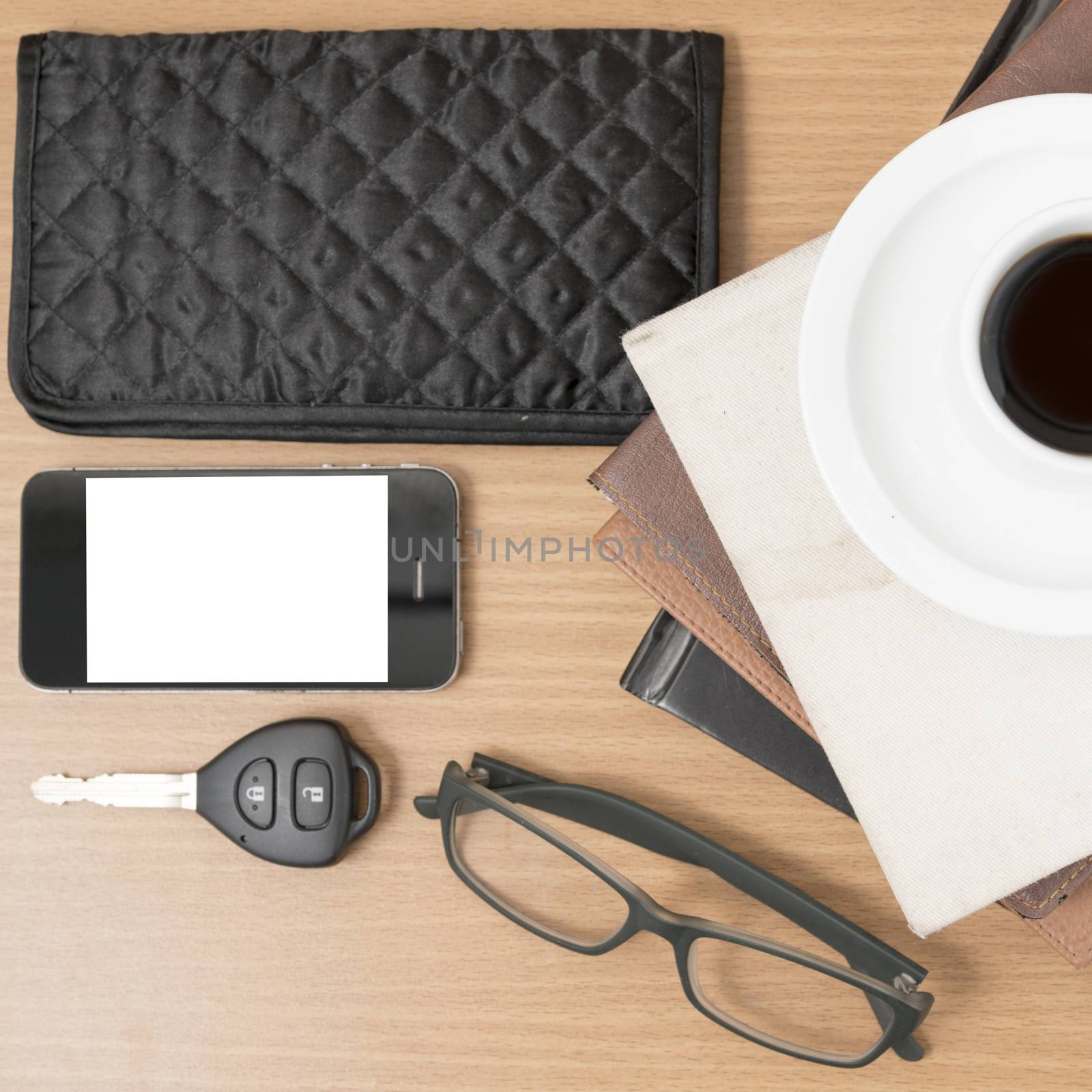 coffee and phone with stack of book,car key,eyeglasses and wallet on wood background