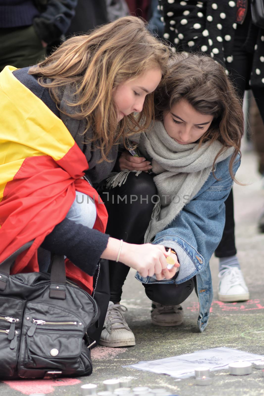 BELGIUM, Brussels: Two girls light a candle as people gather to to pay tribute to the victims of the Brussels airport and metro bombings, on the Place de la Bourse in central Brussels, on March 23, 2016, a day after the triple blasts killed at least 31 people and left around 250 injured. World leaders united in condemning the carnage in Brussels and vowed to combat terrorism, after Islamic State bombers killed around 35 people in a strike at the symbolic heart of the EU.