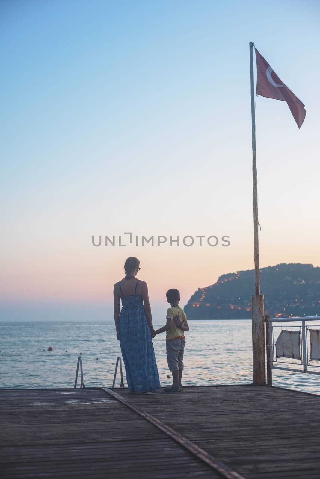 mother and son on the pier in the evening at Alania, Turkey