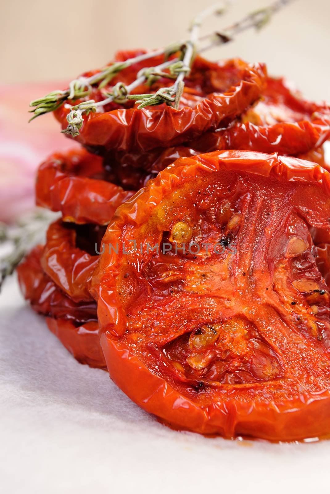 pile of dried tomatoes stacked on a baking paper with cumin and garlic