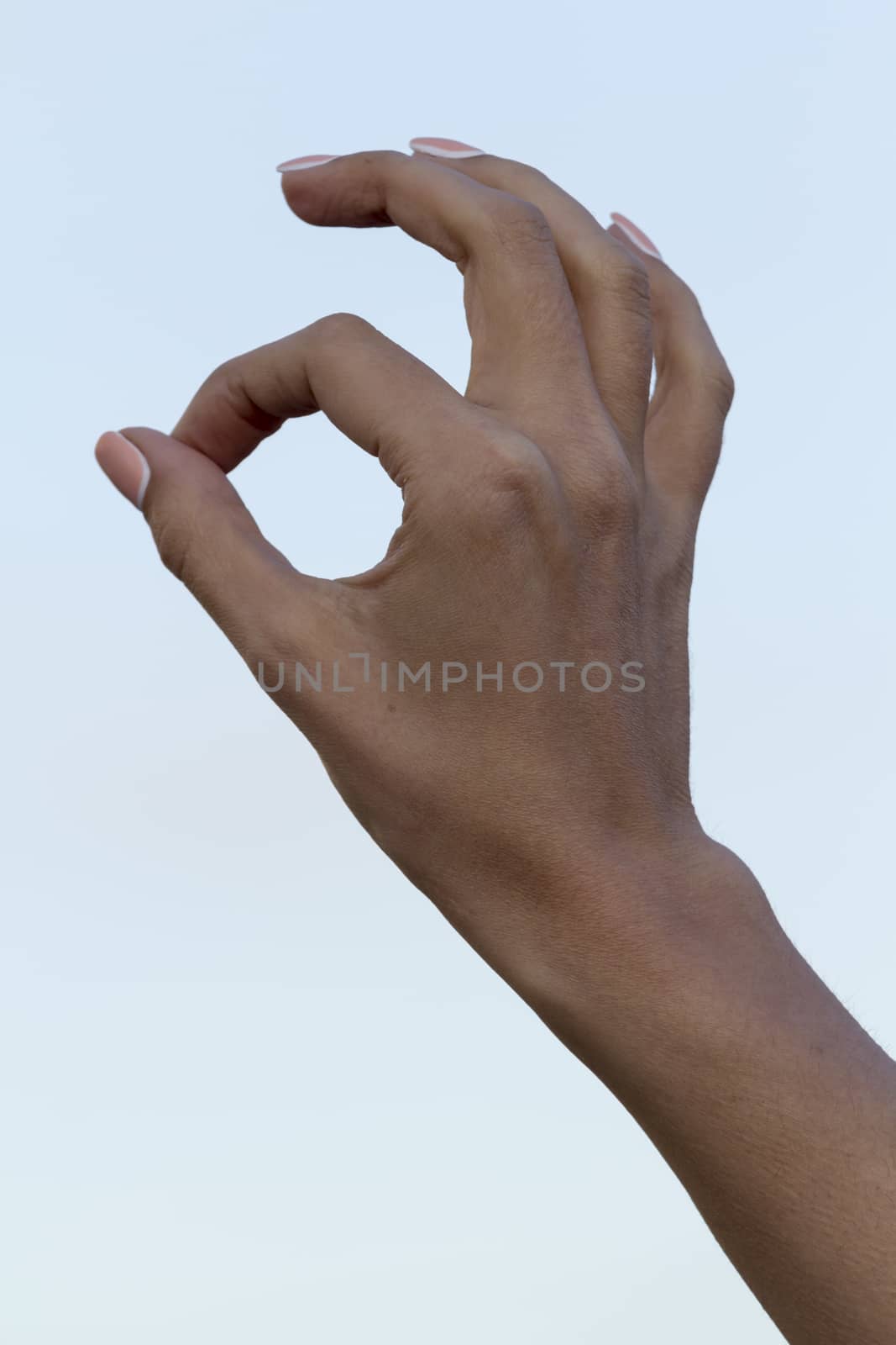girl's hand against the blue sky