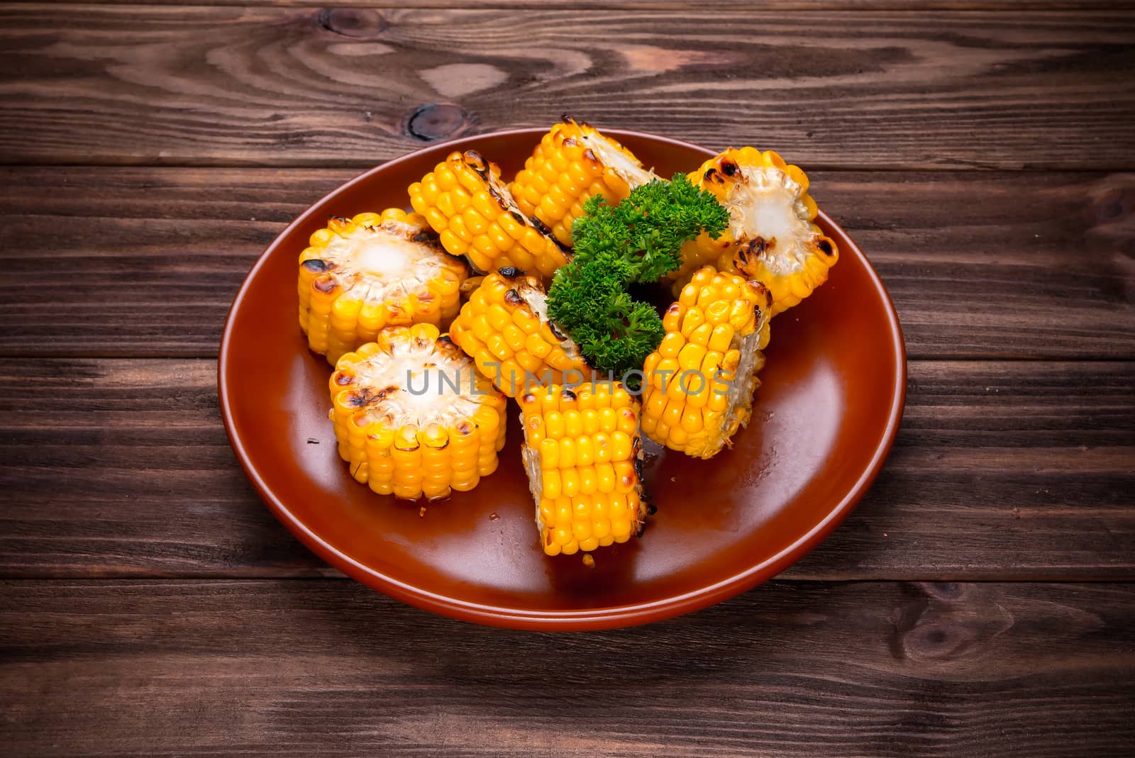 Grilled corn vegetables with greens on wooden background