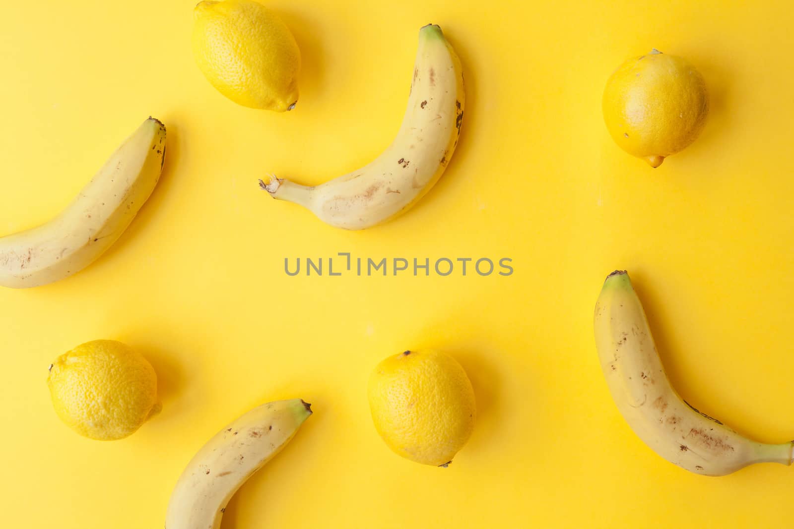 Peel banana and fruit and lemons  on a yellow background and colorful background