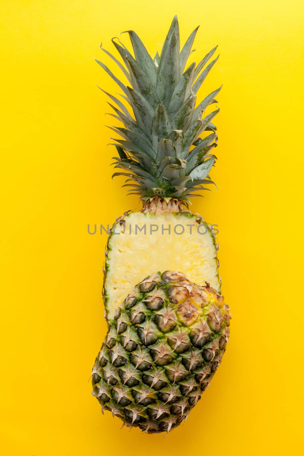 Natural and complete pineapple on a solid yellow background and flat