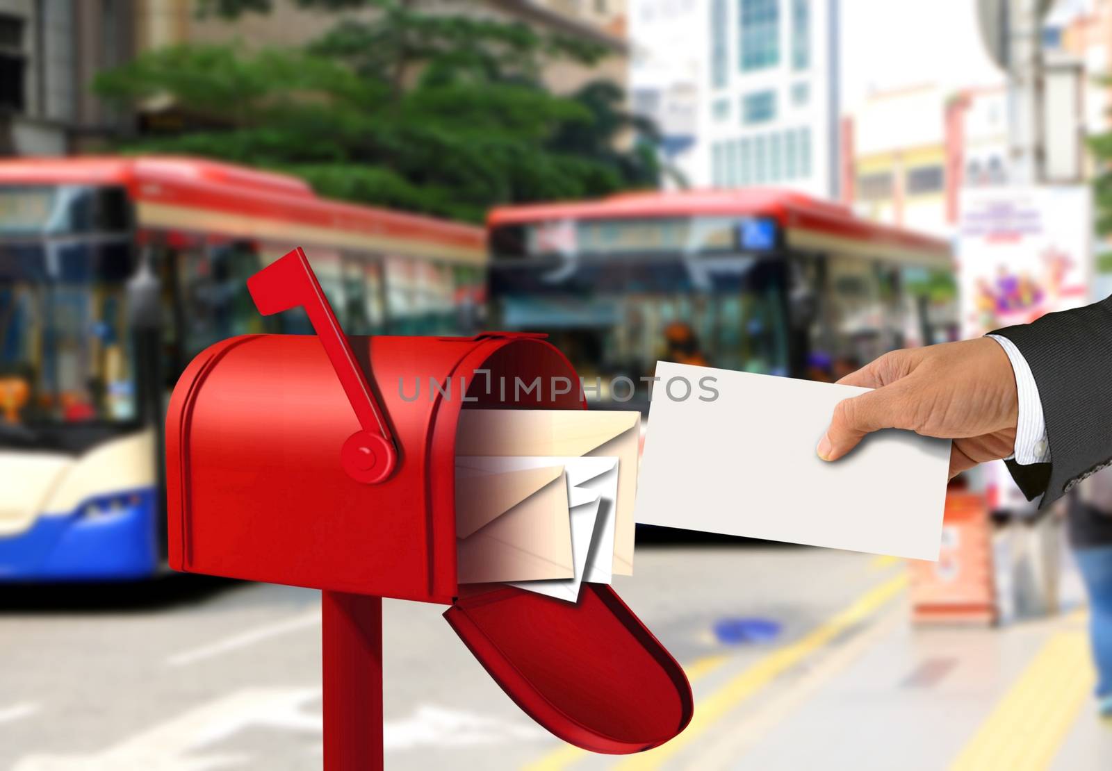 Hand taking a letter from a red postal box