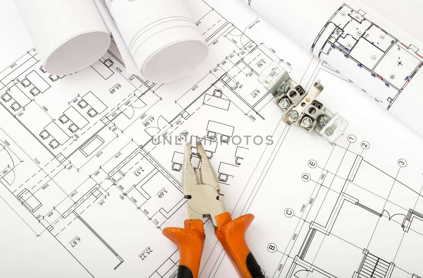 Architecture plan and rolls of blueprints with pliers. Building concept