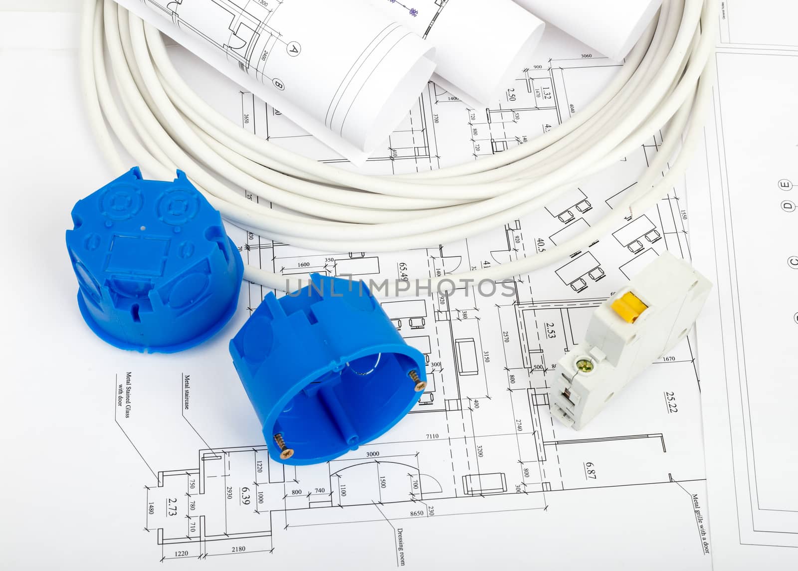 Architecture plan and rolls of blueprints with cabel and blue plastic covers, closeup. Building concept