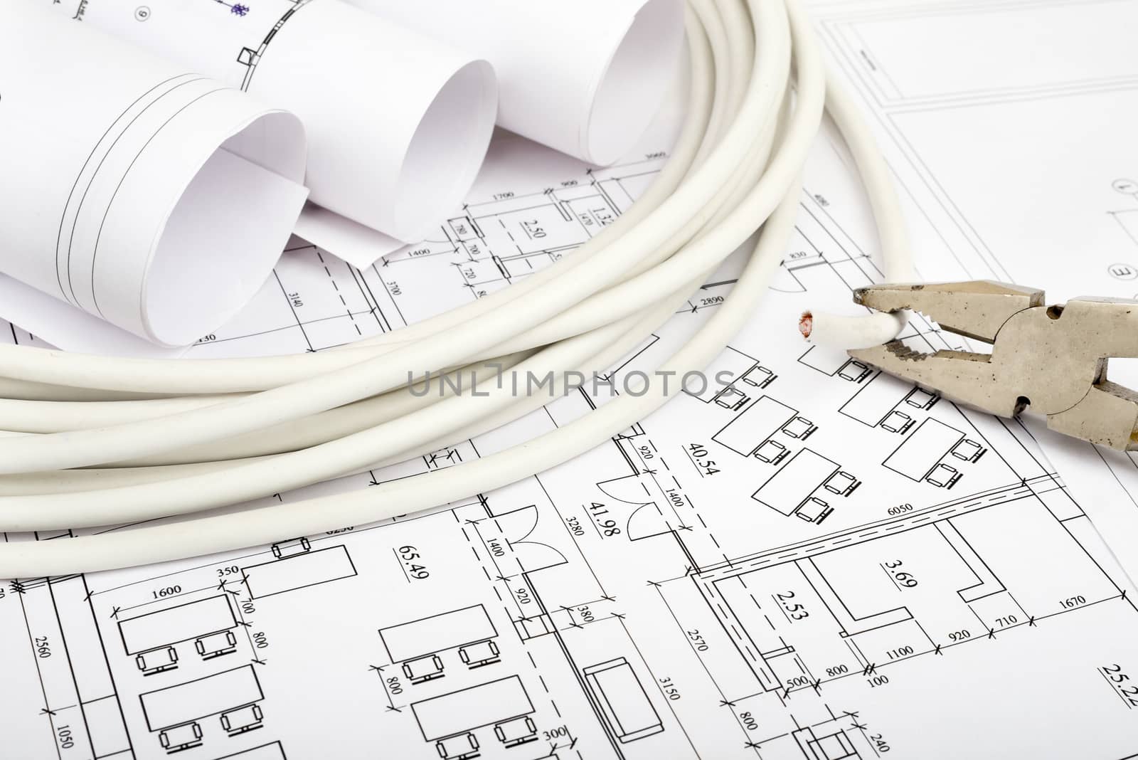 Architecture plan and rolls of blueprints with cabel and pliers. Building concept