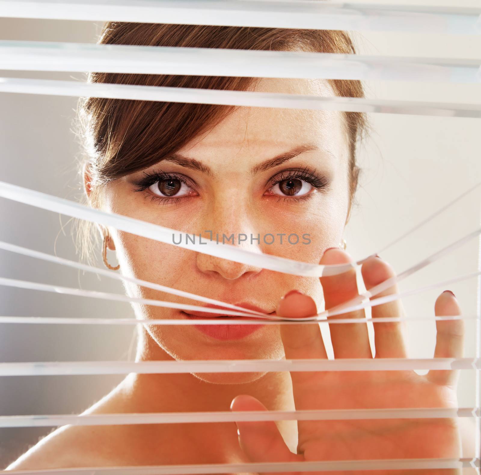 look of woman who observes through blinds