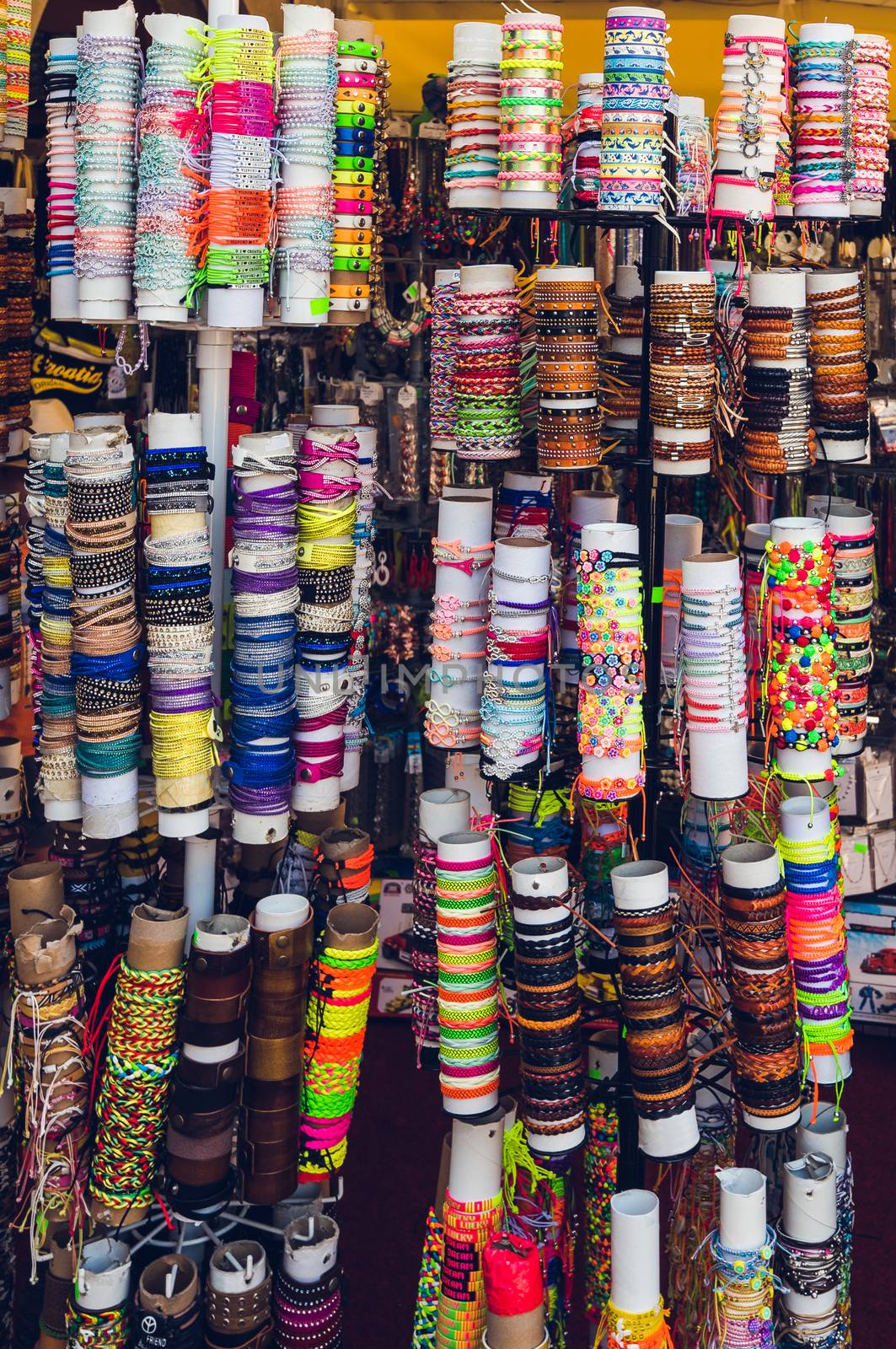 Many Different Colorful Bracelets in the Souvenir Shop on Paper Rolls