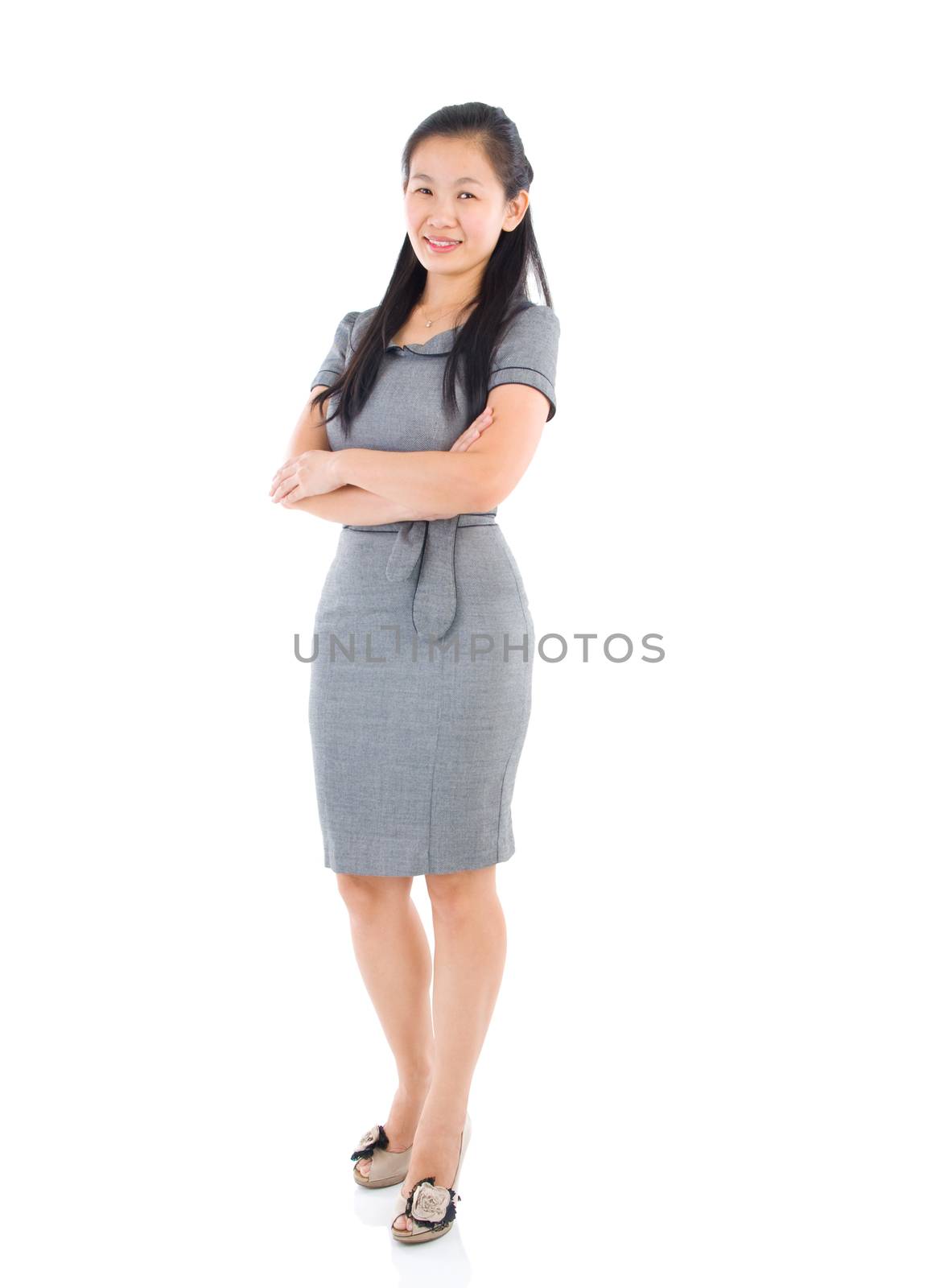 Full body Asian business woman standing on plain background.