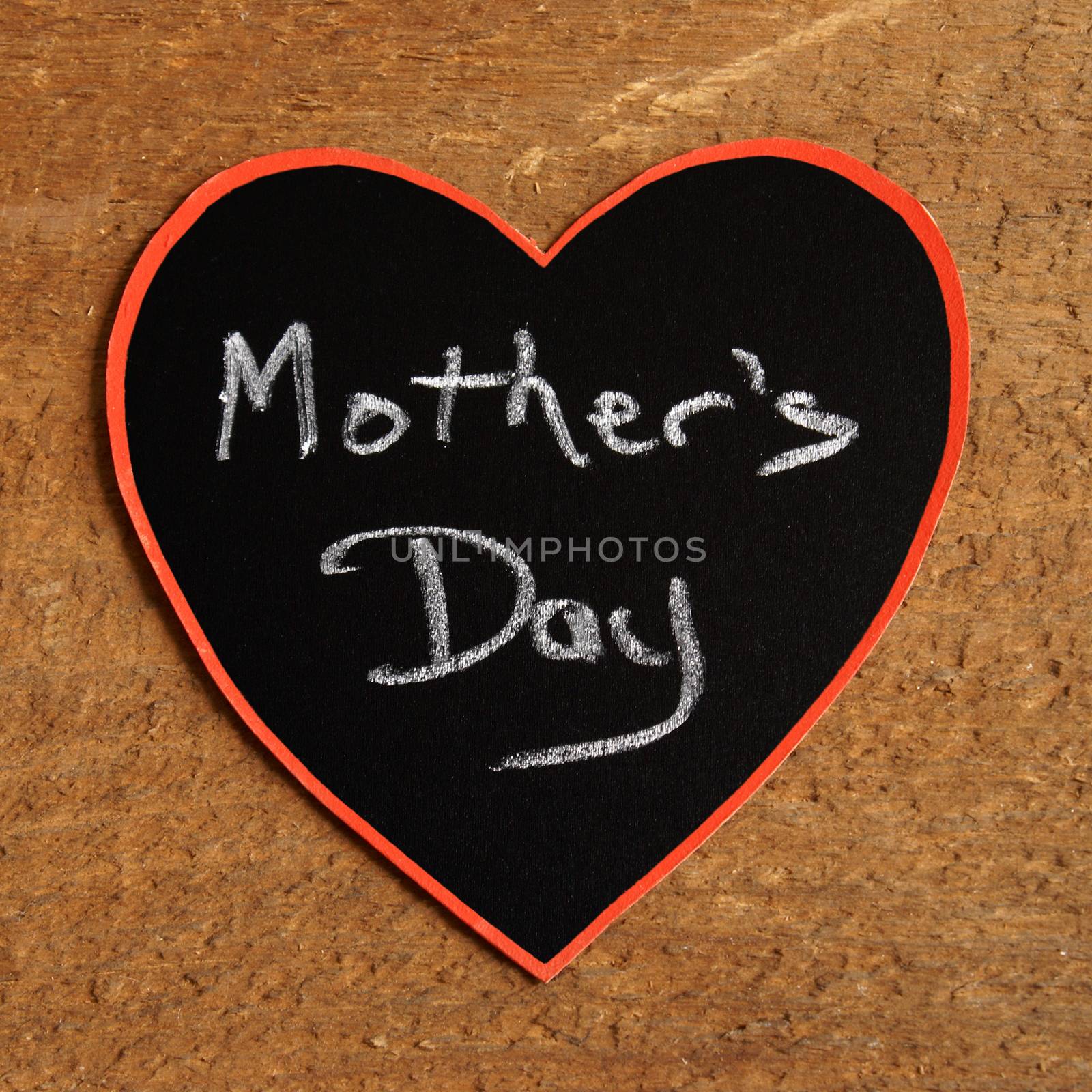 A heart with a mothers day announcement using a chalkboard.
