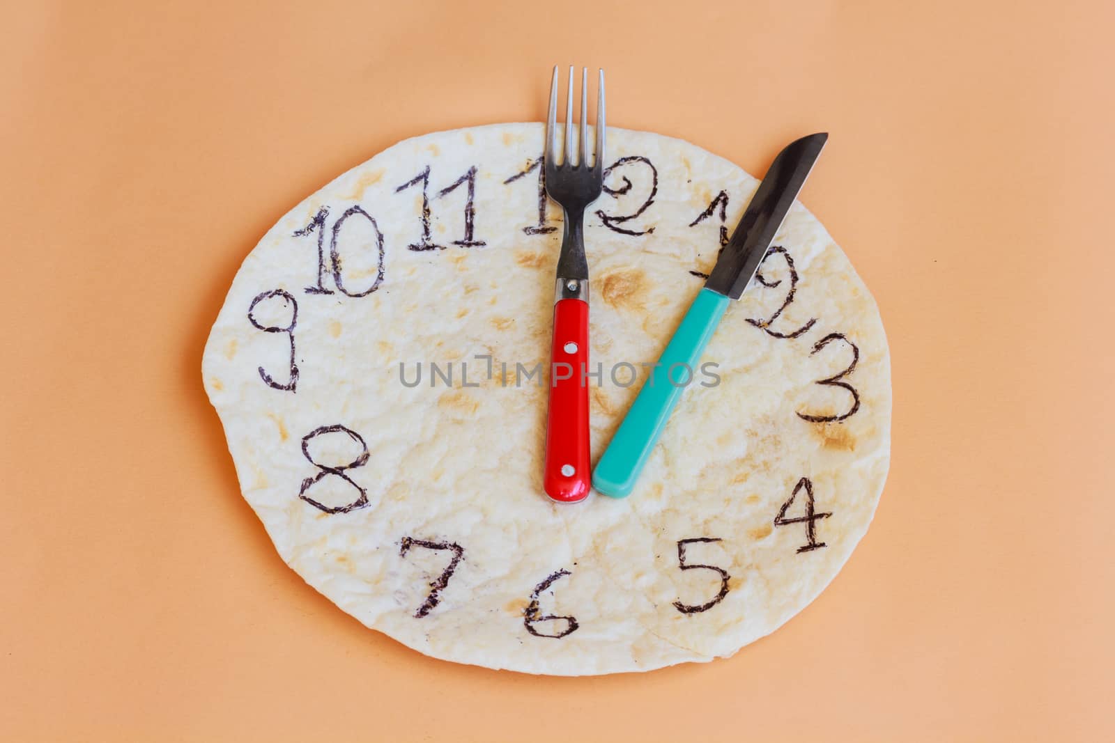 a white piadina forms a clock with red and green hands remember that is an italian product