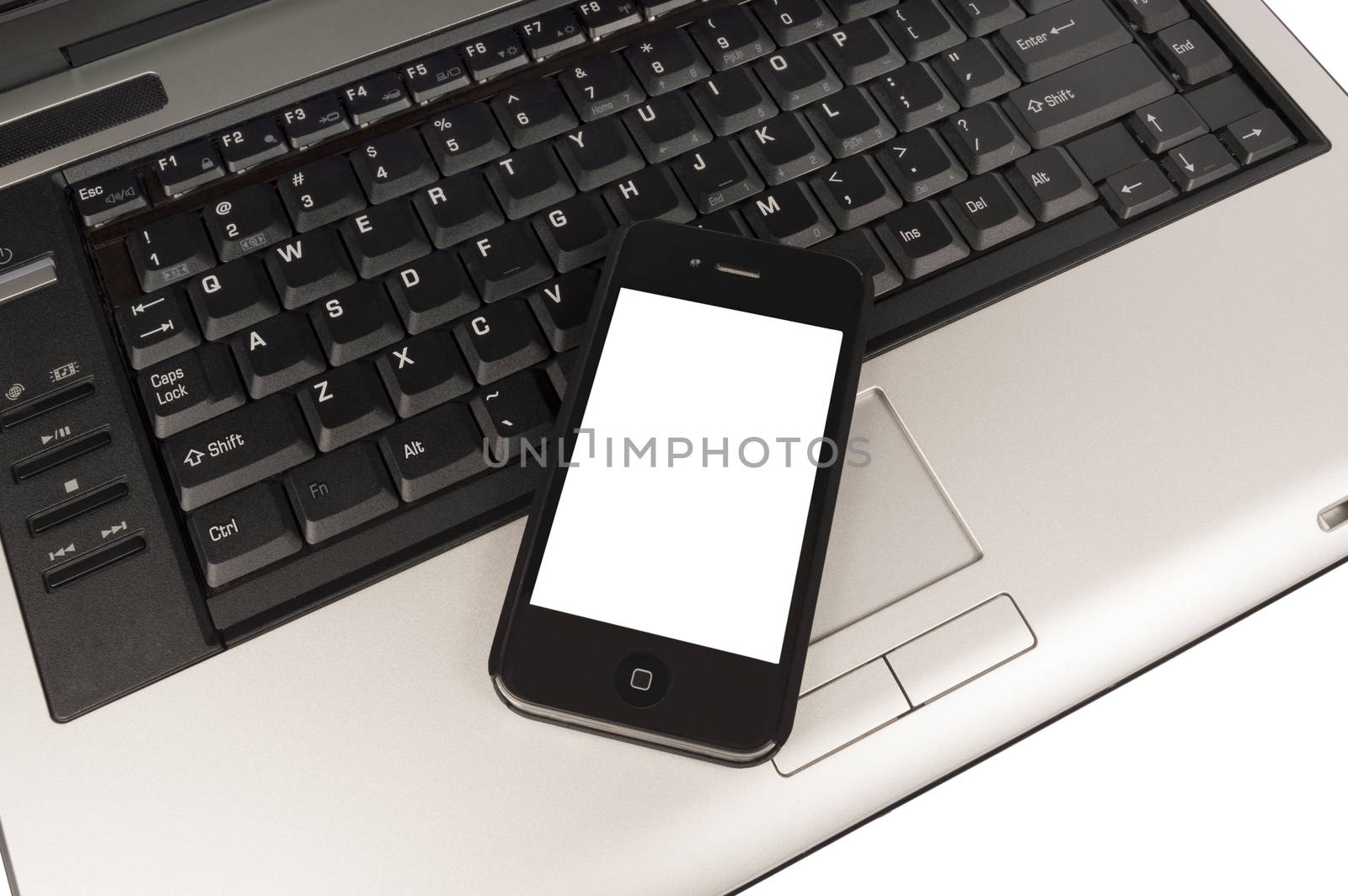 Over head view of business phone with blank screen for your copy resting on keyboard of laptop.