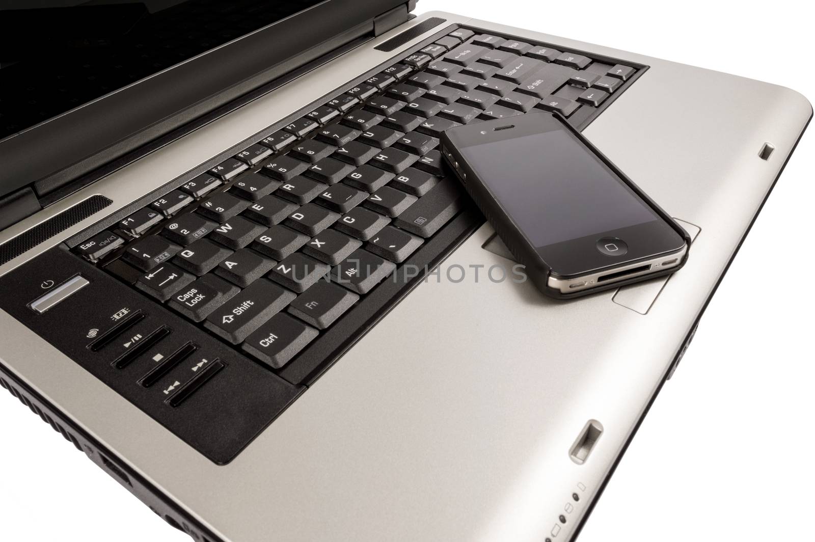 Shot on angle is a laptop with mobile phone resting on keyboard.