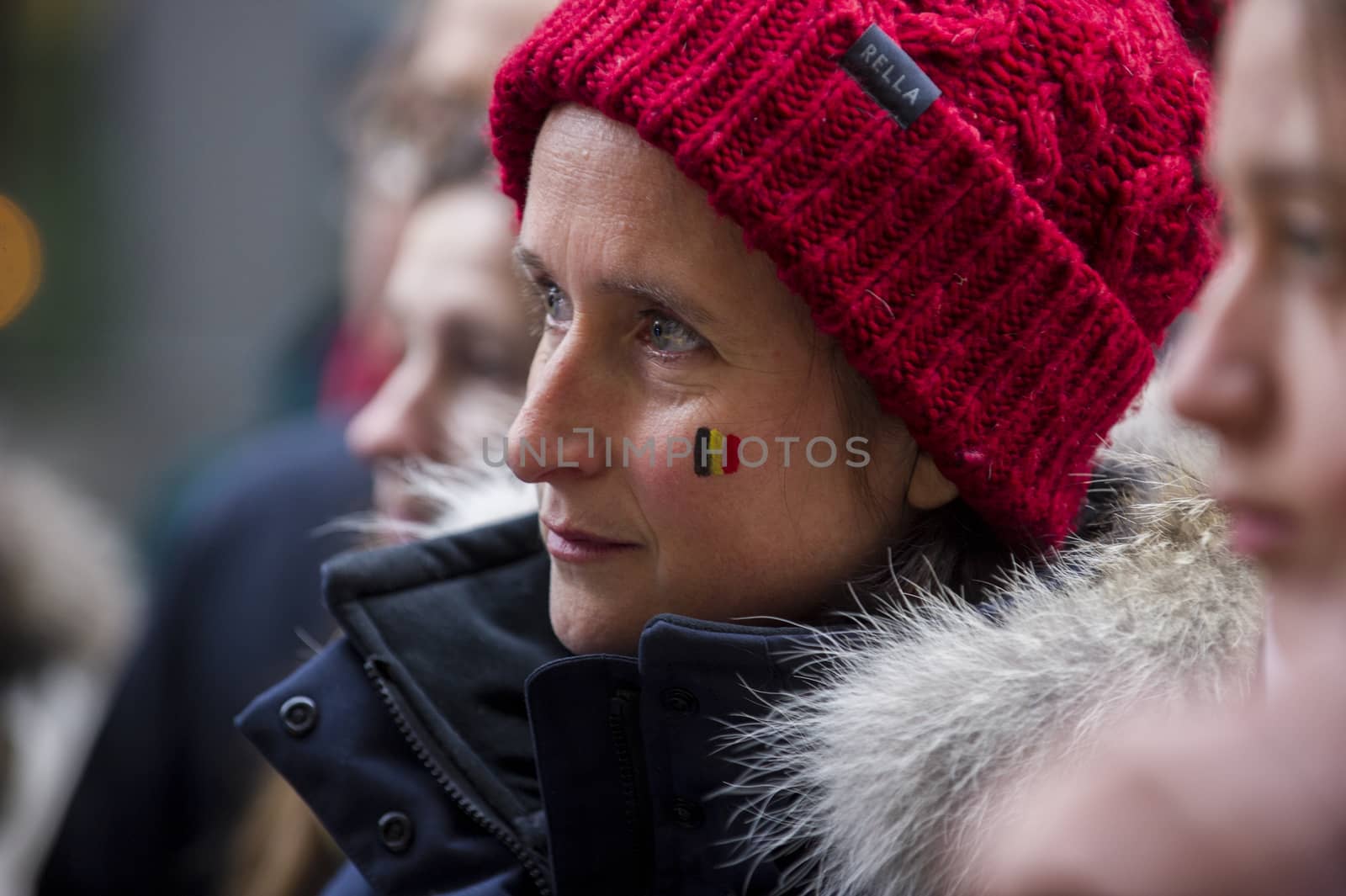 CANADA, Montreal: A woman's face bears the Belgian flag at a vigil in Montreal, Canada on March 23, 2016 for the victims of the attacks in Brussels that killed at least 30 people and injured hundreds of others the day before. Responsibility for the bombings at Zavetum airport and Molenbeek metro station was later taken by the Islamic State terror group.
