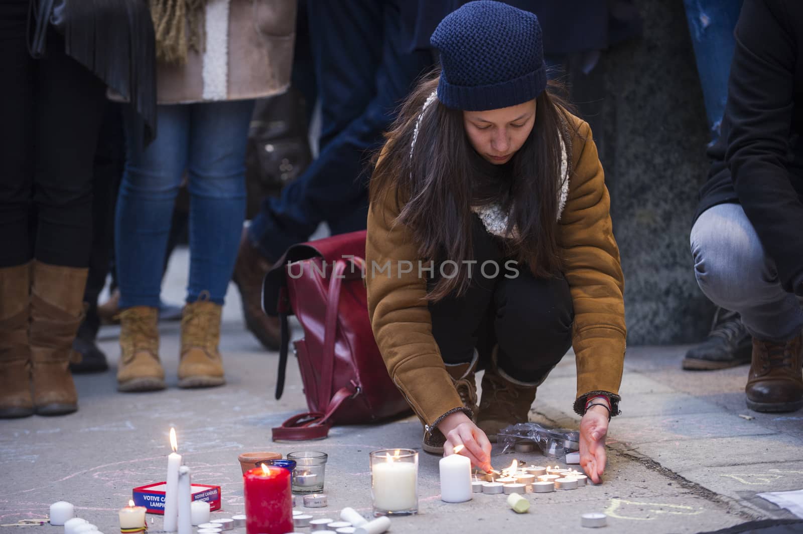 CANADA, Montreal: A woman lights candles at a vigil in Montreal, Canada on March 23, 2016 for the victims of the attacks in Brussels, Belgium that killed at least 30 people and injured hundreds of others the day before. Responsibility for the bombings at Zavetum airport and Molenbeek metro station was later taken by the Islamic State terror group.