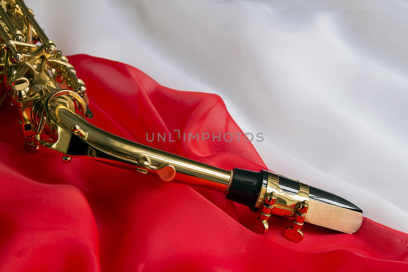 beautiful golden saxophone on delicate red silk background
