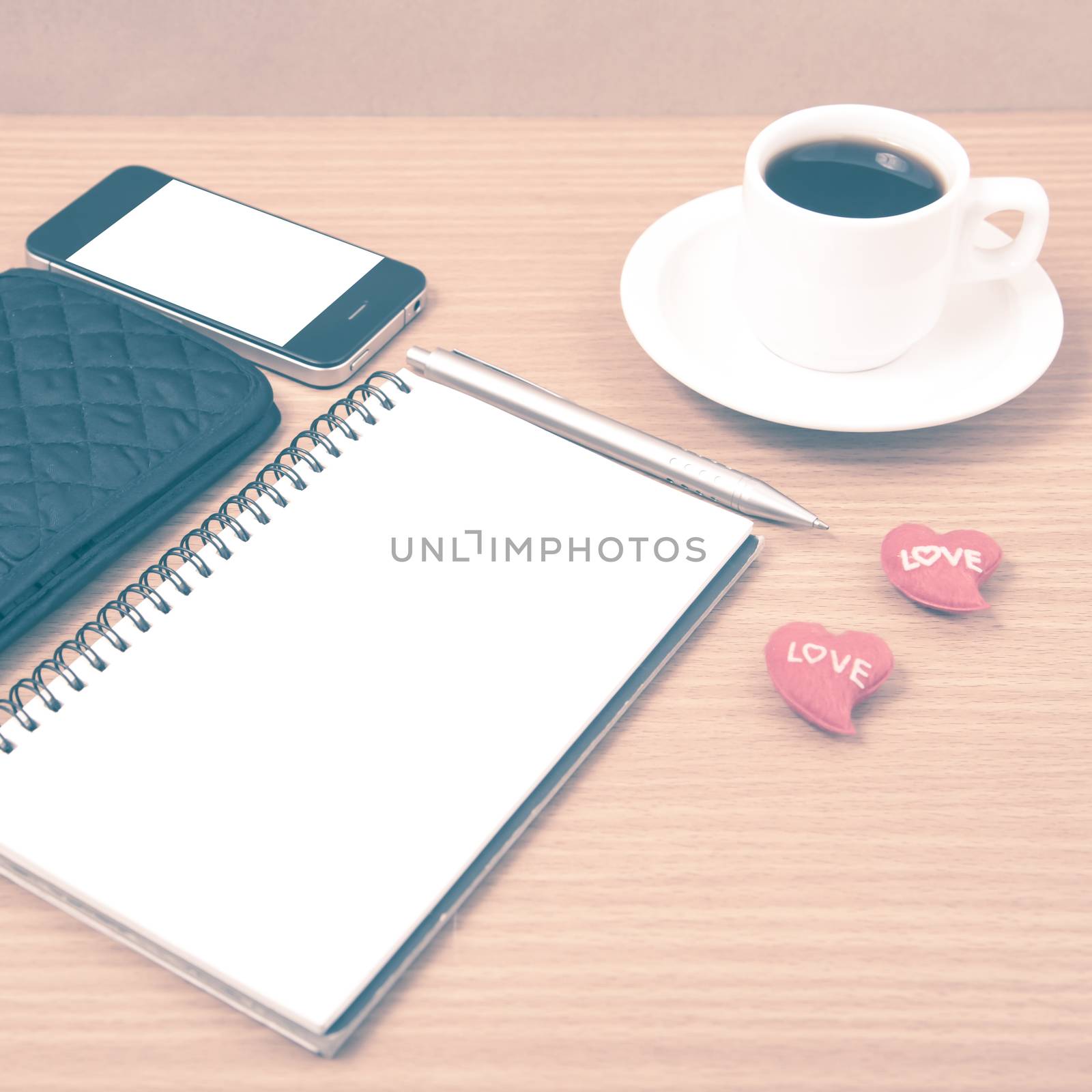 working table : coffee with phone,notepad,wallet and red heart on wood background vintage style