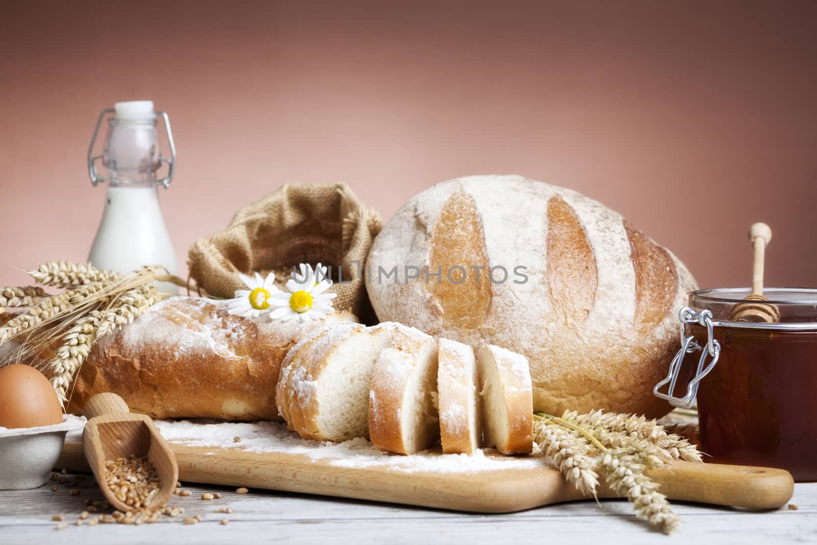 Freshly baked bread,honey and eggs on wooden vintage table