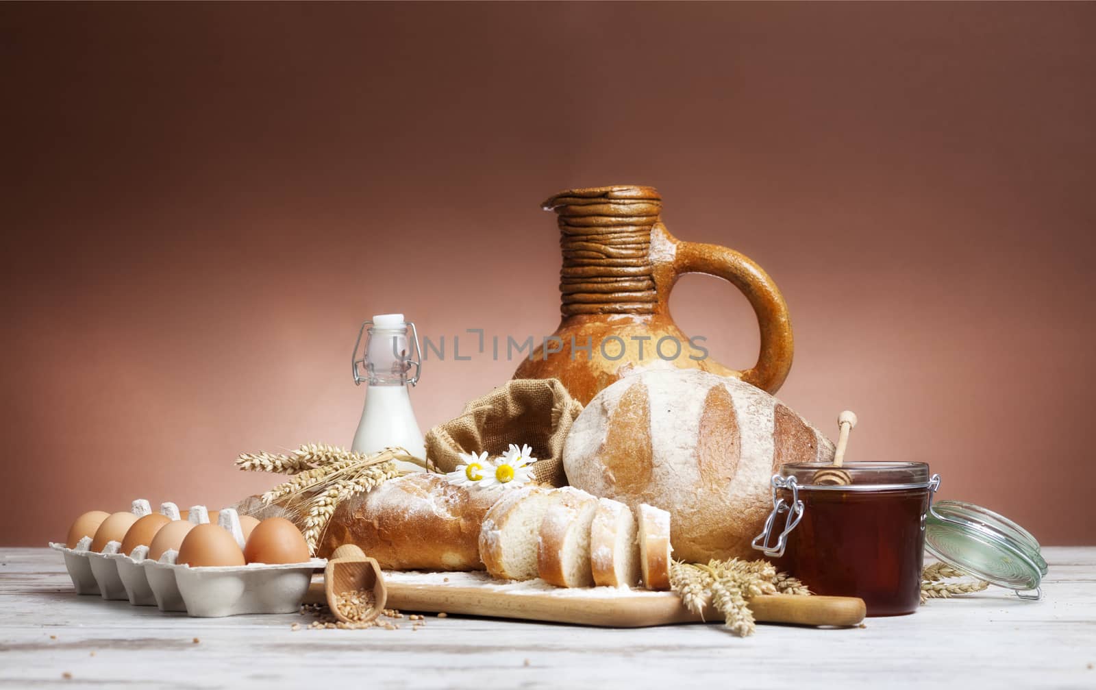 Freshly baked bread,honey and eggs on wooden vintage table