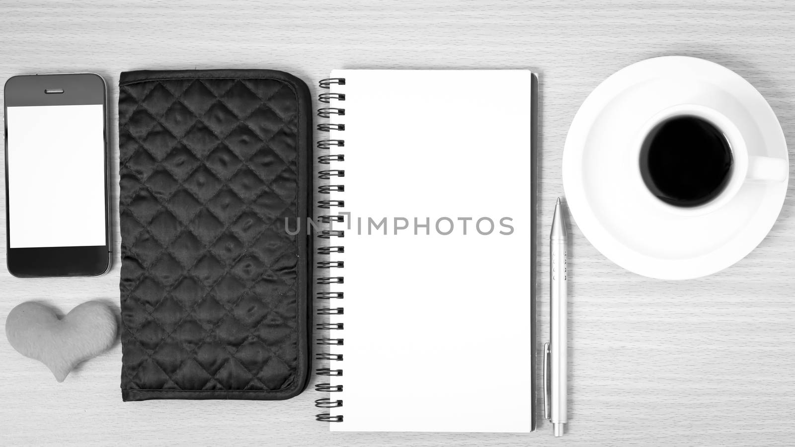 office desk : coffee with phone,heart,notepad,wallet on wood background black and white color