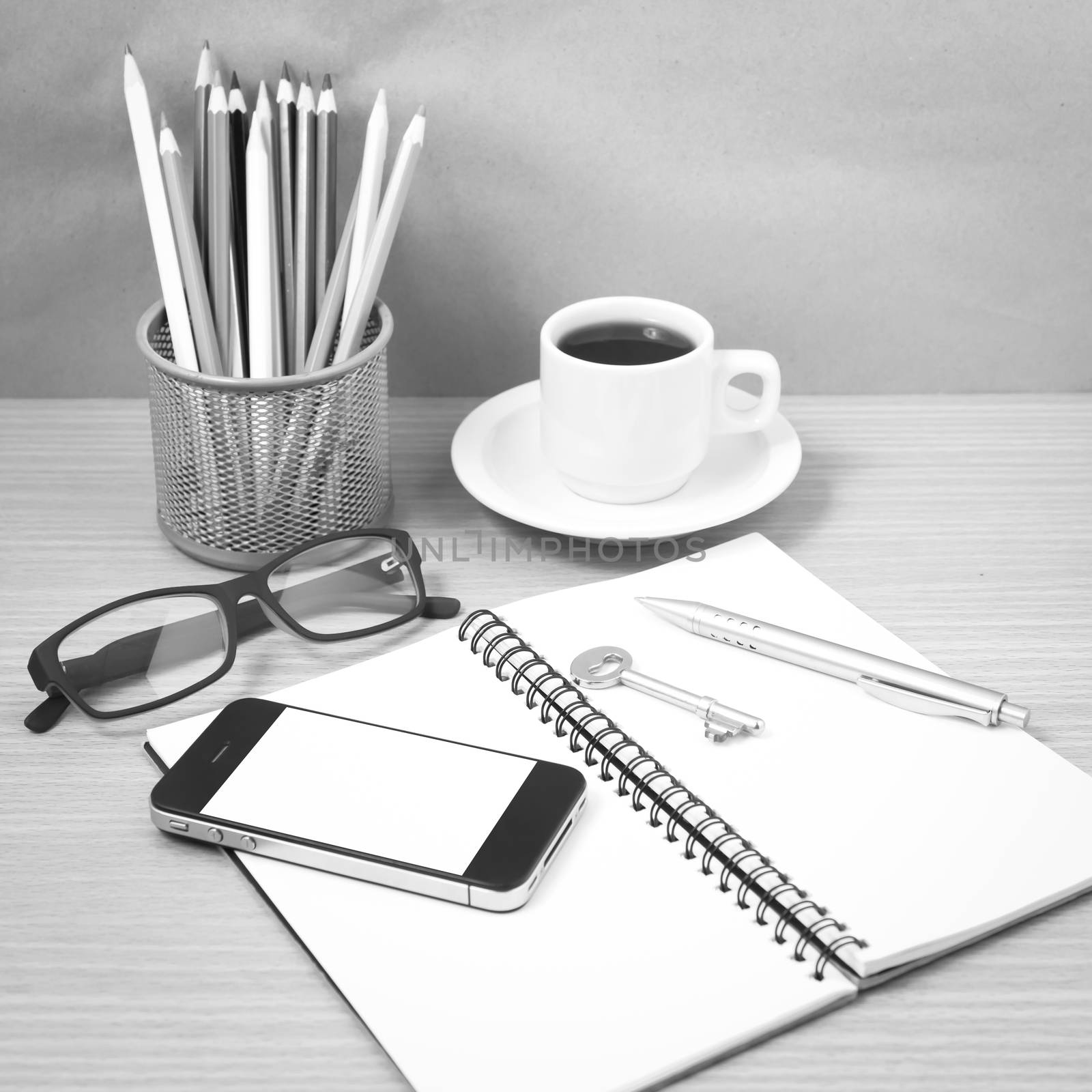 office desk : coffee and phone with key,eyeglasses,notepad,pencil boxblack and white color