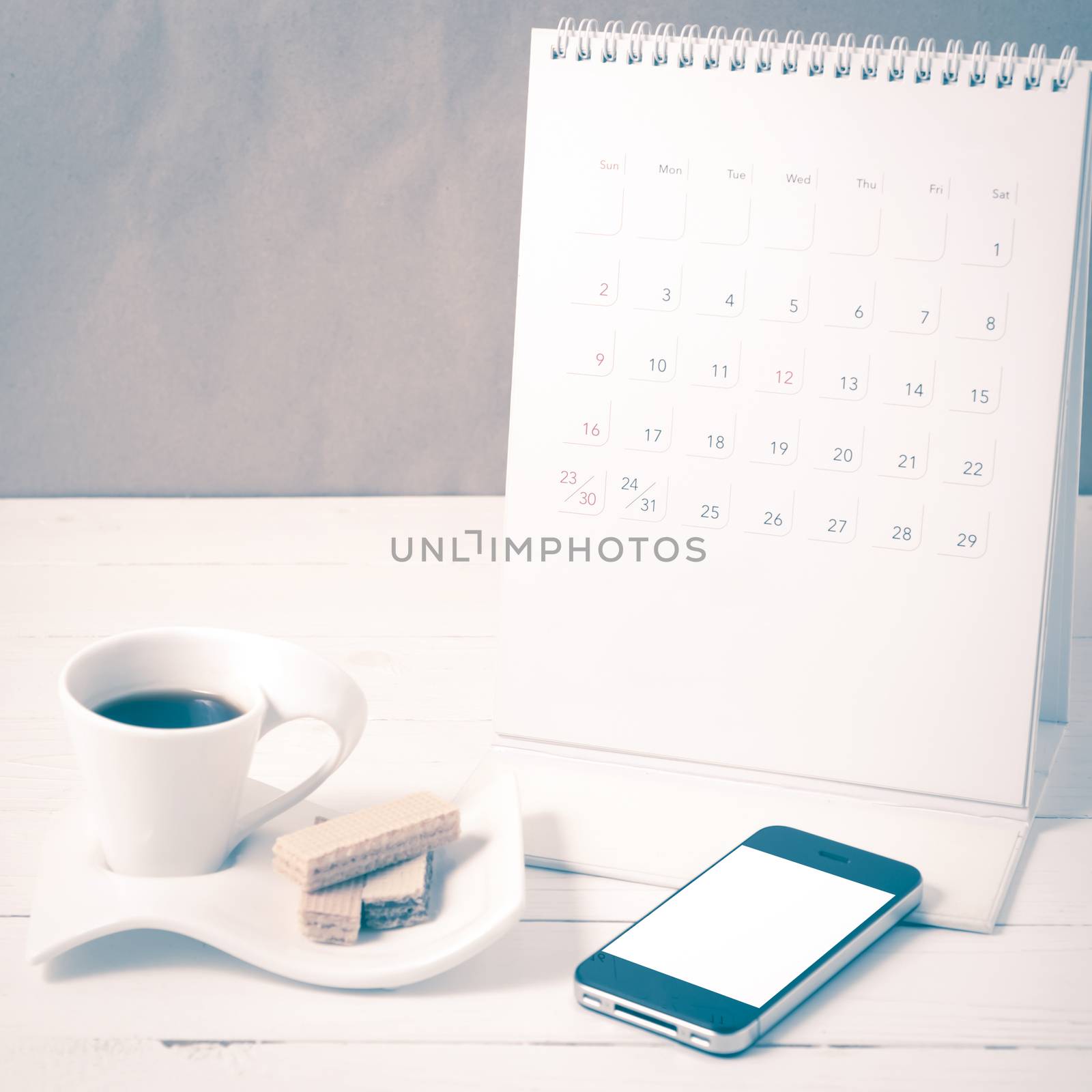 coffee cup with wafer,phone,calendar on white wood background vintage style