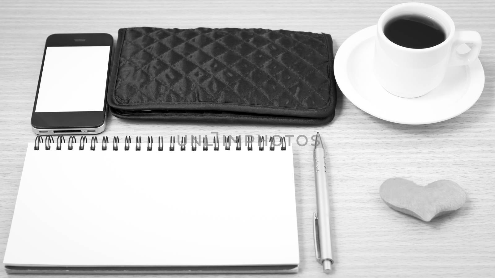 office desk : coffee with phone,heart,notepad,wallet on wood background black and white color