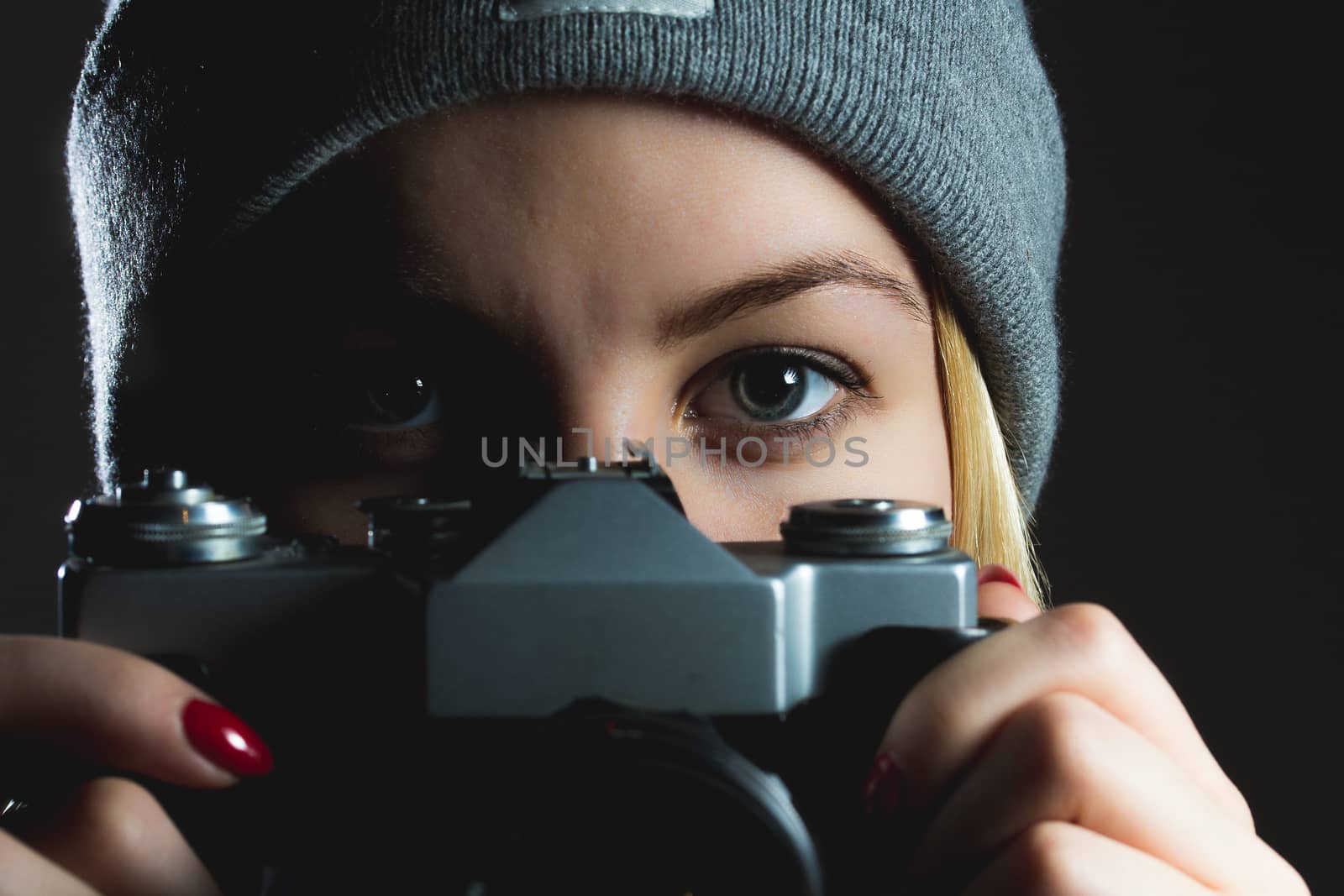 closeup of hipster girl eyes taking picture with retro camera by eddgars