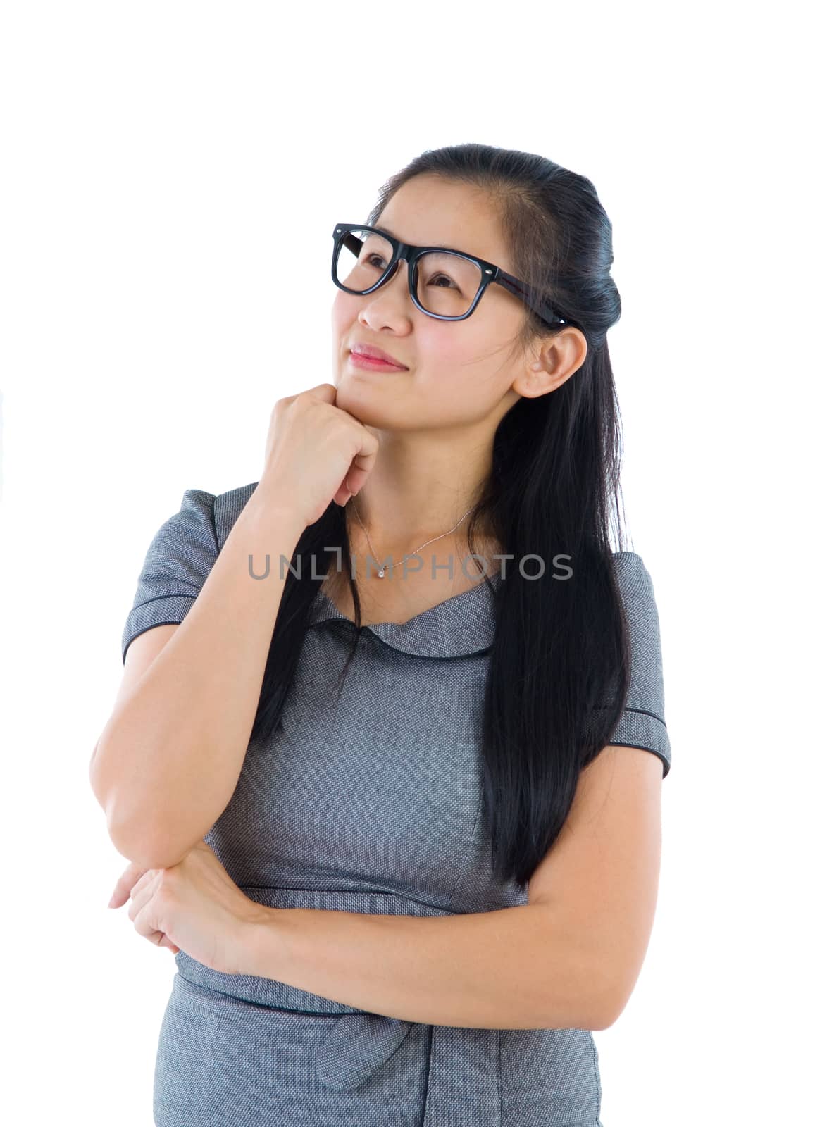 Businesswoman having a thought, looking up smiling happy. Portrait of beautiful Asian female model standing isolated on white background.