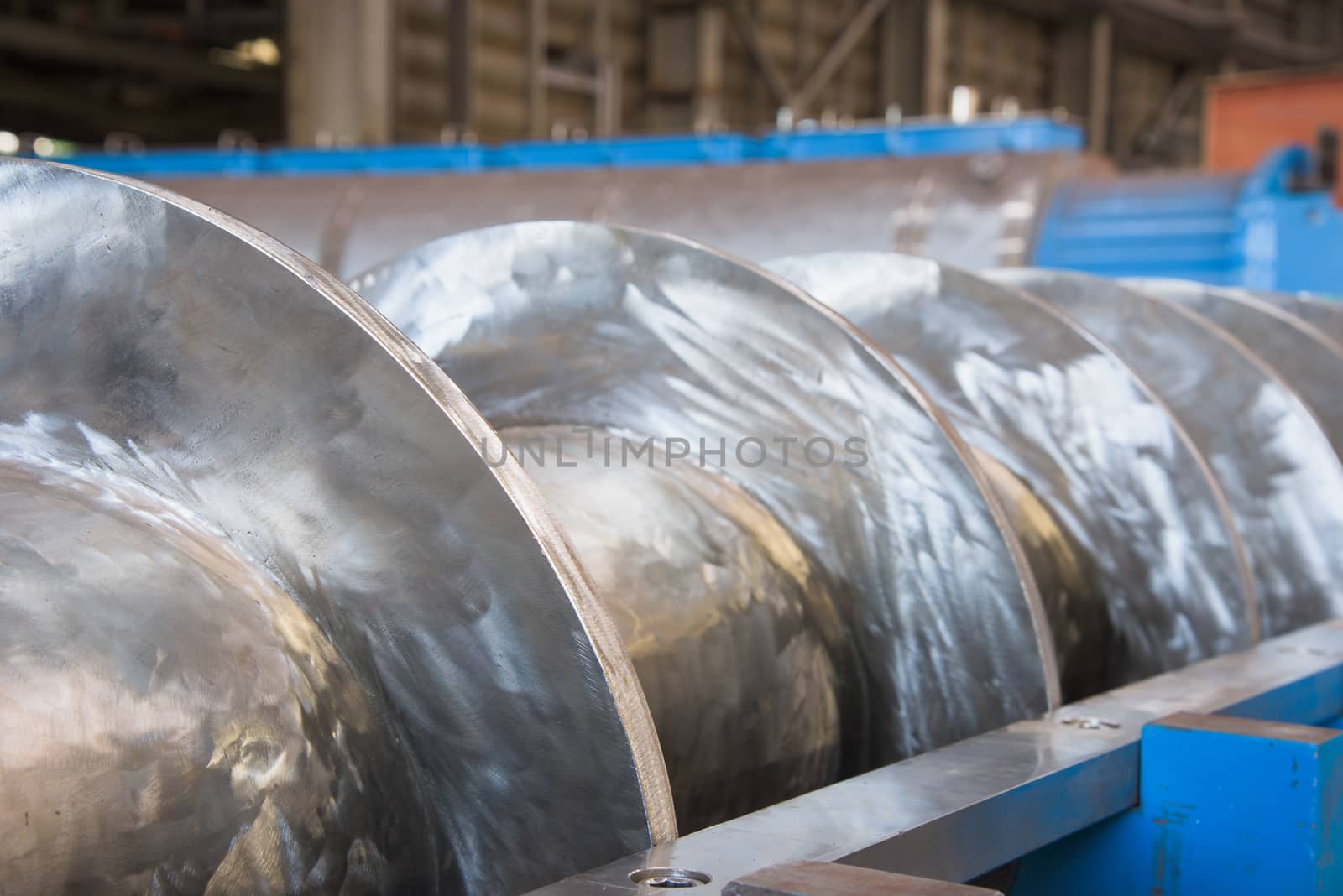 Industrial twin screw press for processing of waste from meat production during construction. SSemi-abstract with very shallow depth of field.