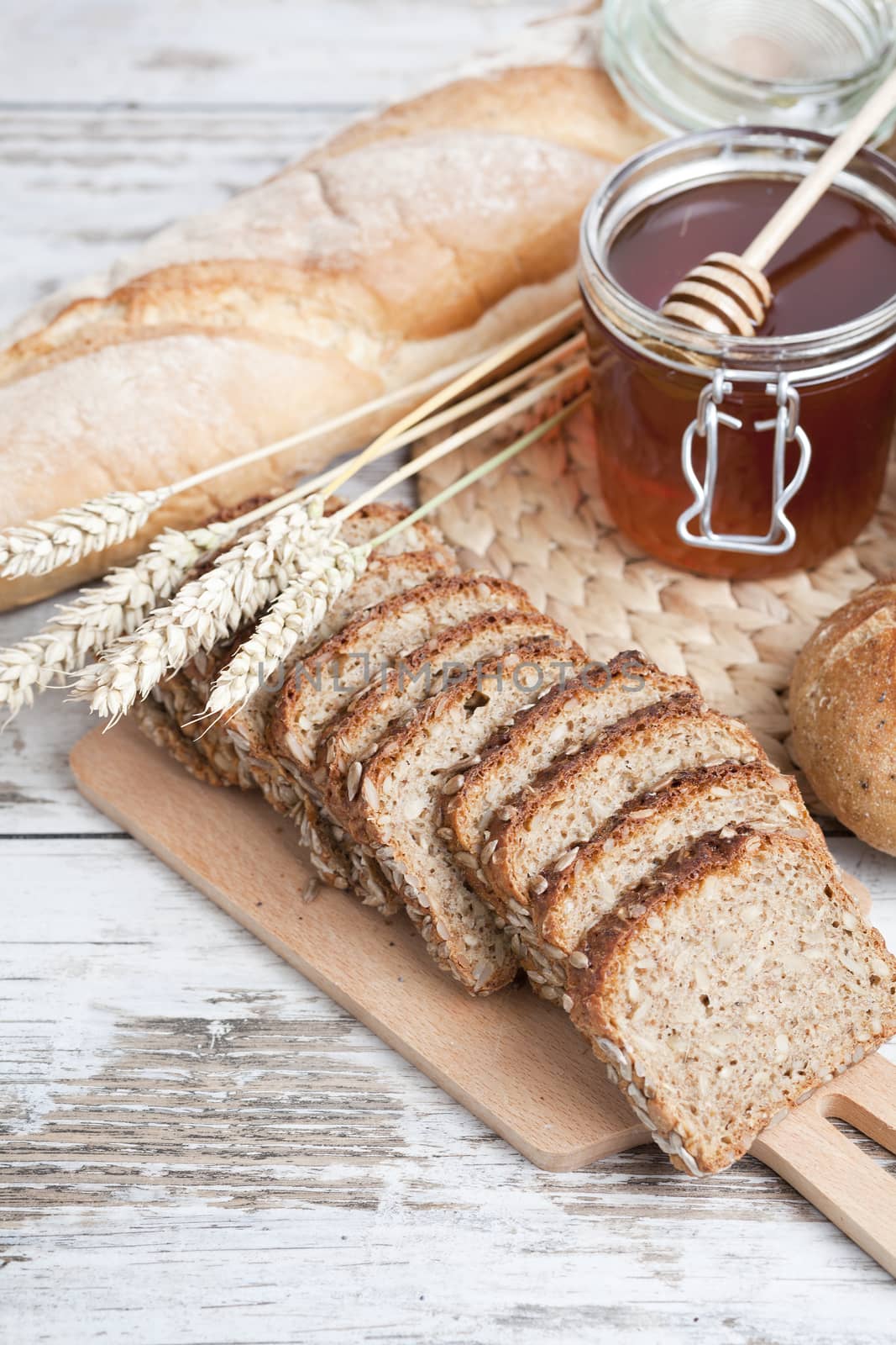 Freshly baked bread rolls, wheat ears and honey