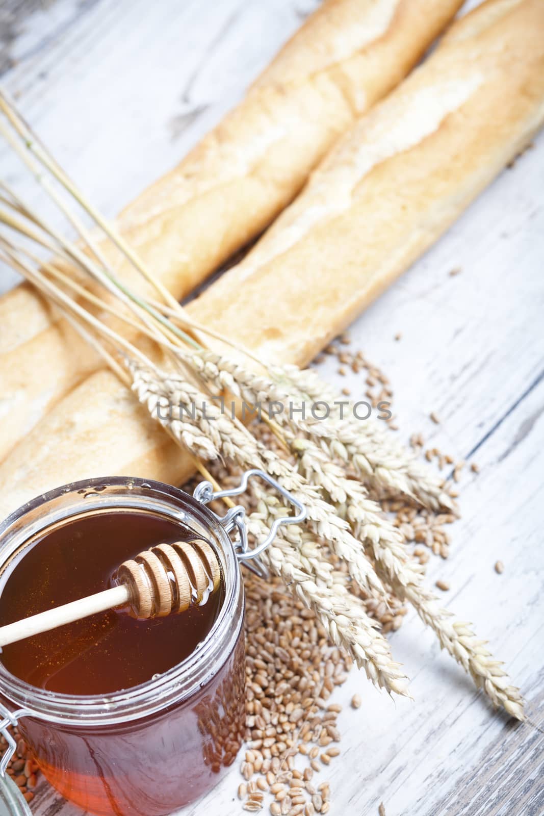 Freshly baked bread rolls, wheat ears and honey