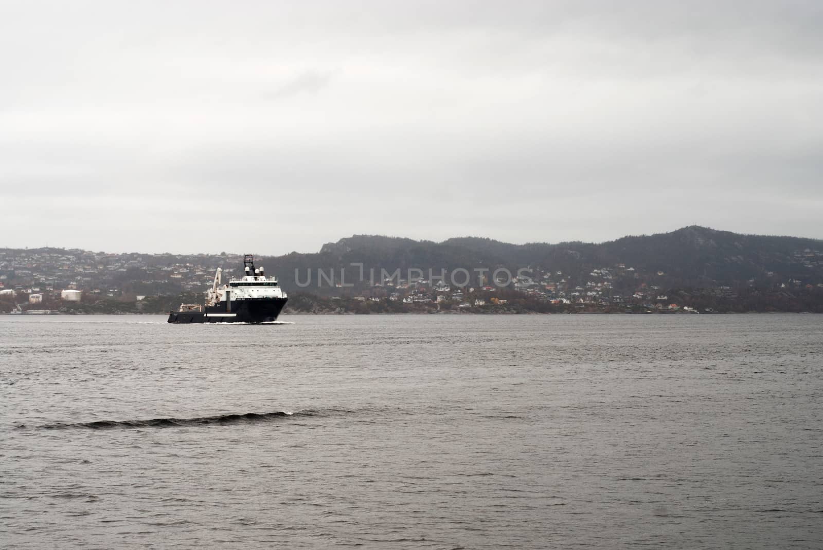 Cargo vessel is coming to port of Bergen, Norway