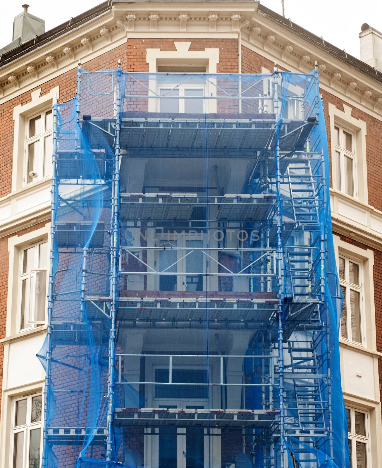 restoration facade of old house under blue net