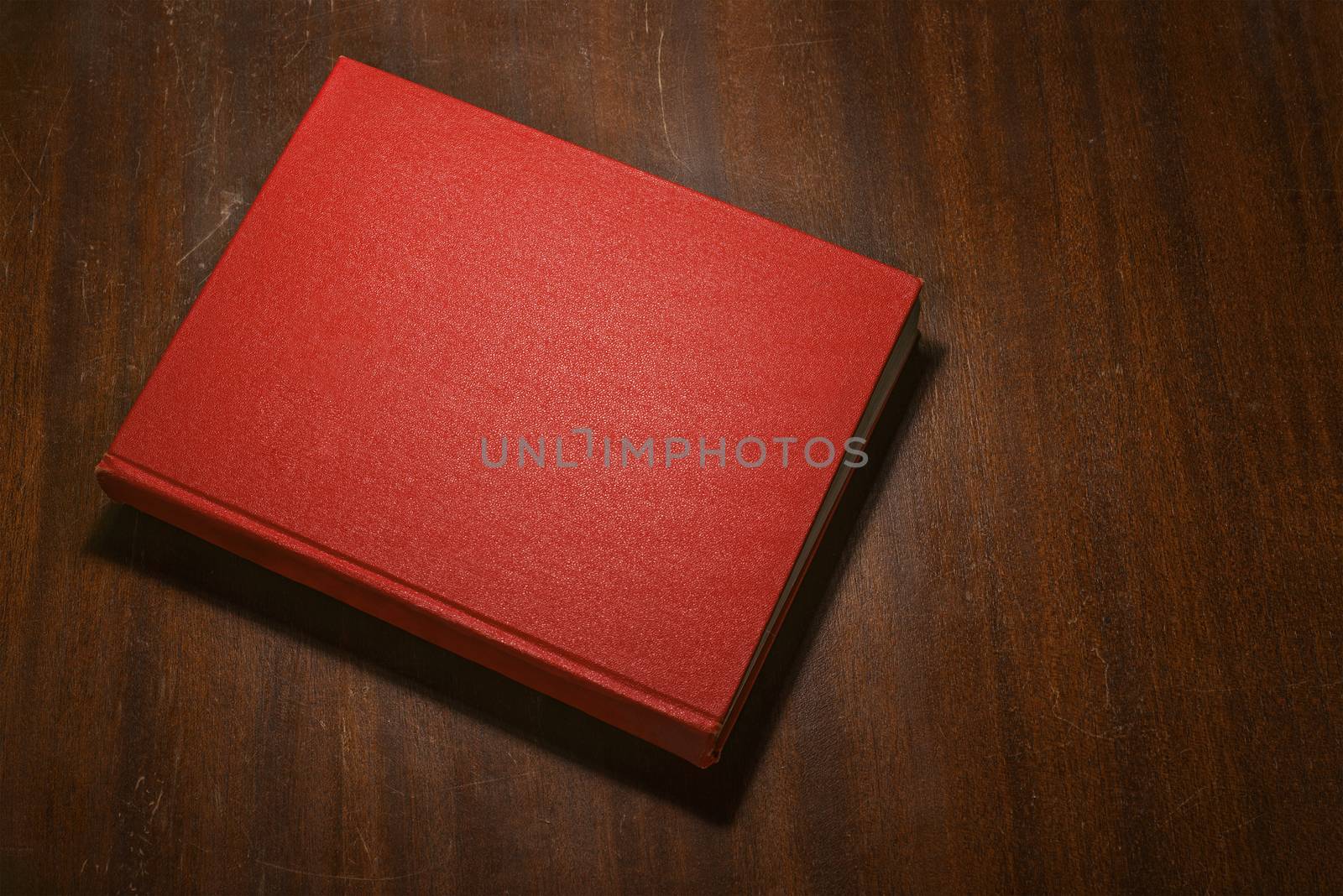 Red book on the wooden scratched table