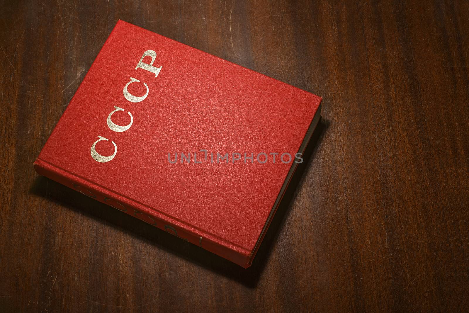 VILNIUS, LITHUANIA - NOVEMBER 24, 2015:  Red book on the wooden scratched table,  CCCP  written on the cover, Illustrative Editorial Image