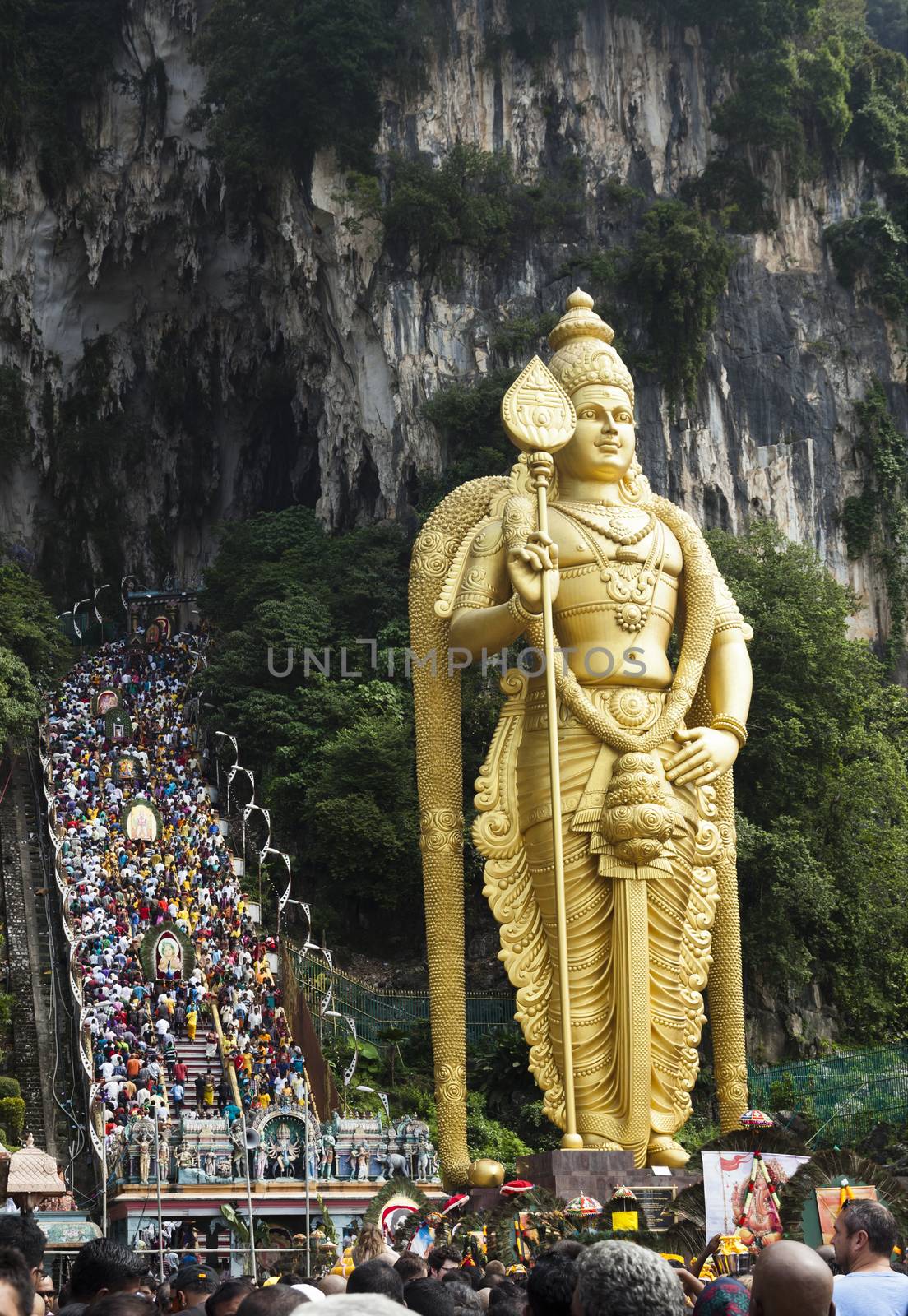 Photo of lord murugan statue standing tall in front the cave entrance taken during Thaipusam at Batu Cave temple, Malaysia .