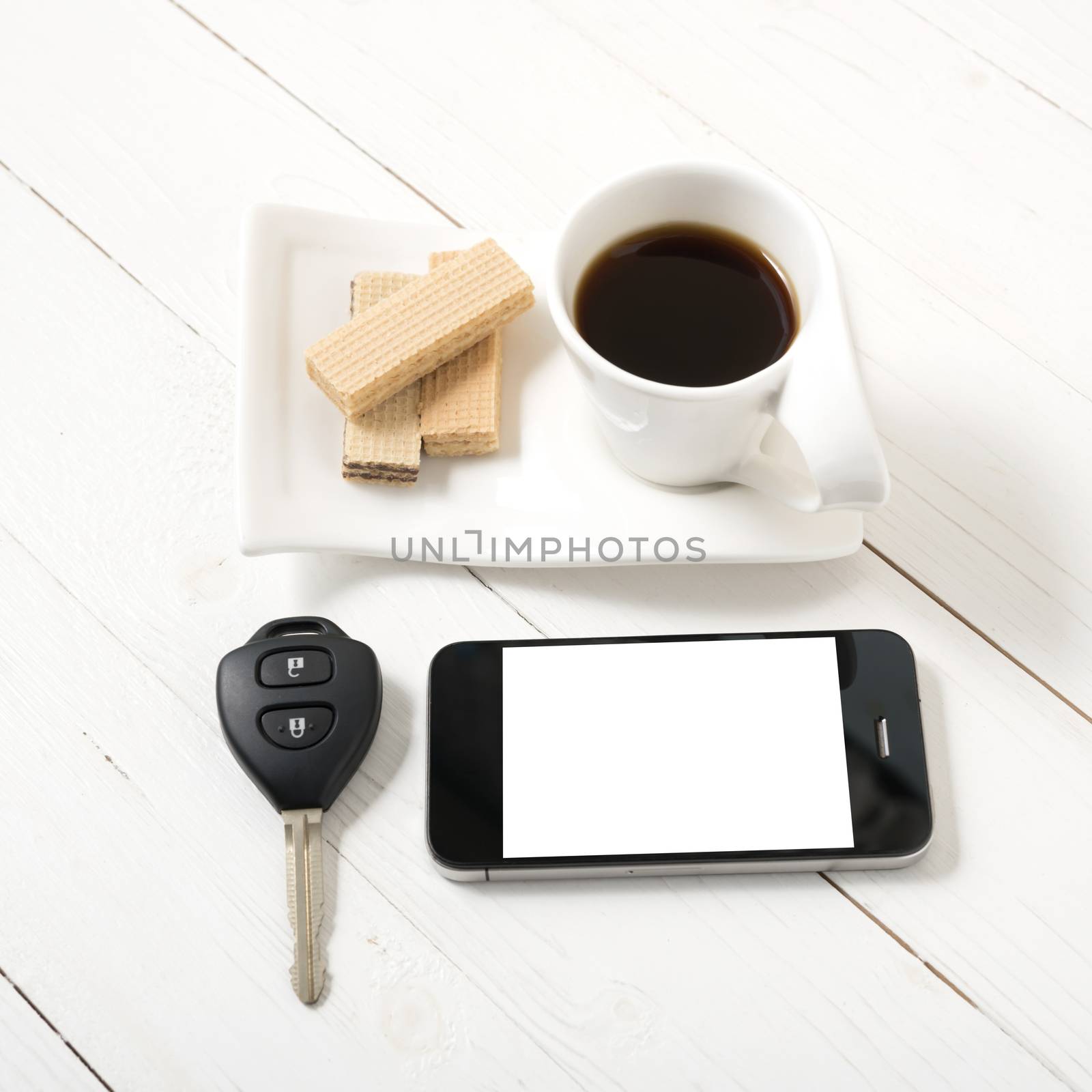 coffee cup with wafer,phone,car key on white wood background