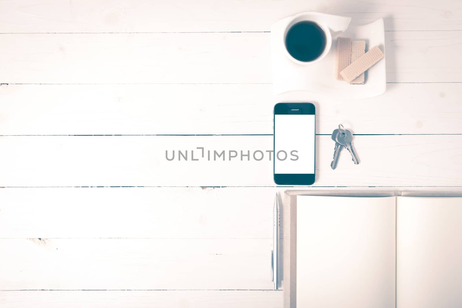 coffee cup with wafer,phone,key,notebook on white wood background vintage style