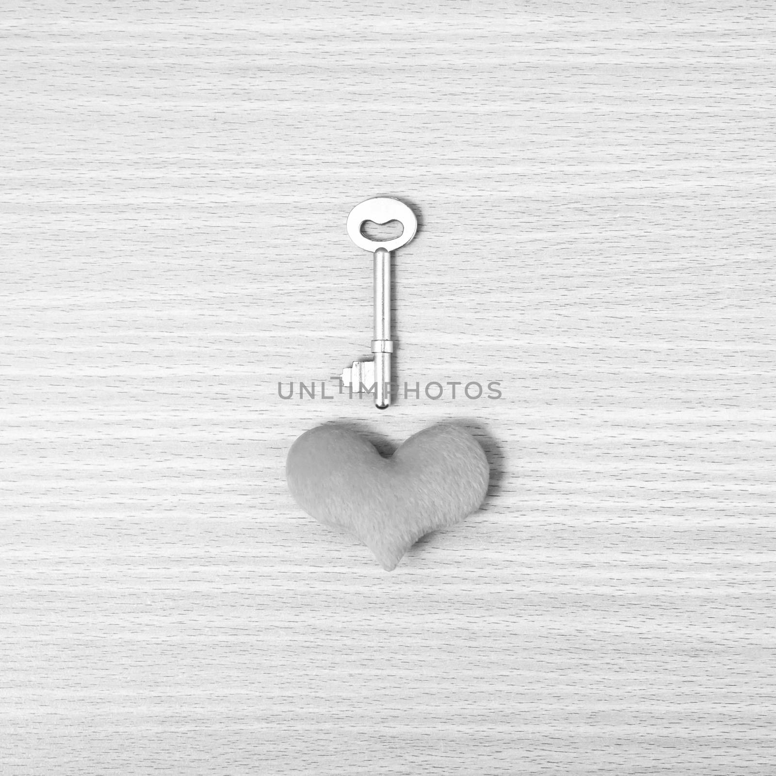 red heart with key on wood table background black and white color