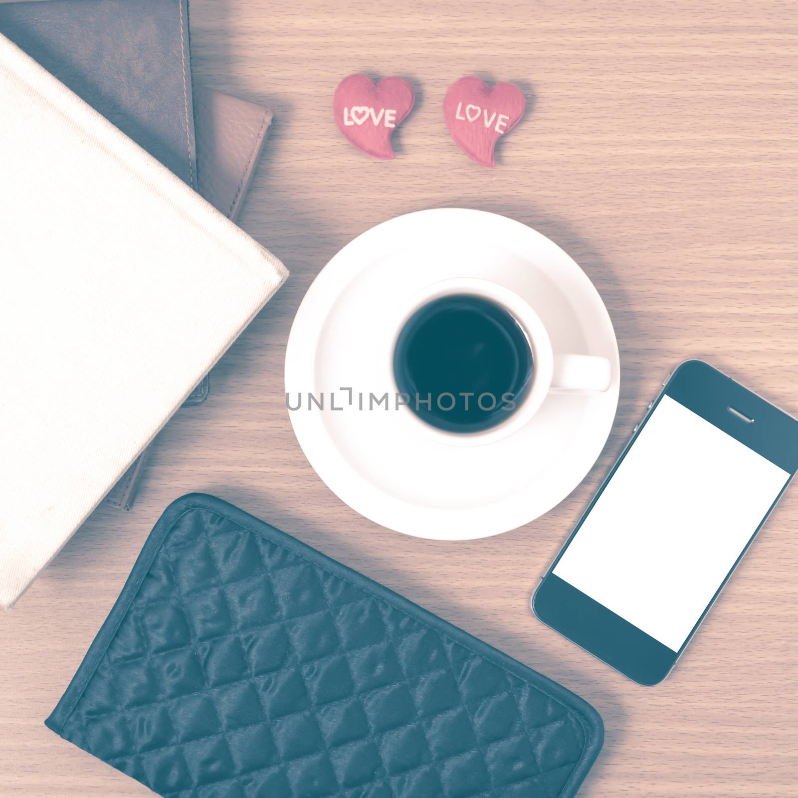 office desk : coffee with phone,heart,stack of book,wallet on wood background vintage style