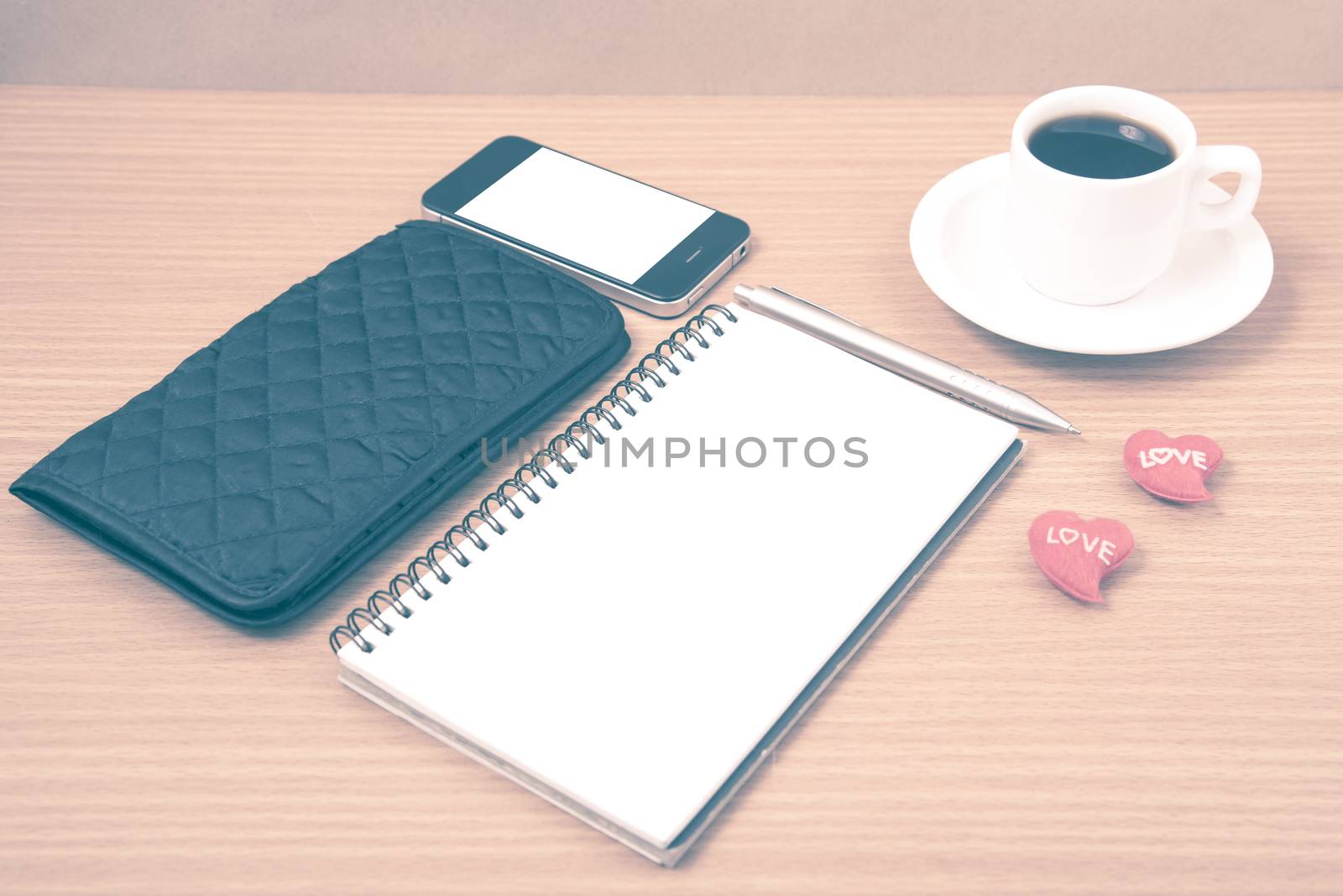 working table : coffee with phone,notepad,wallet and red heart on wood background vintage style