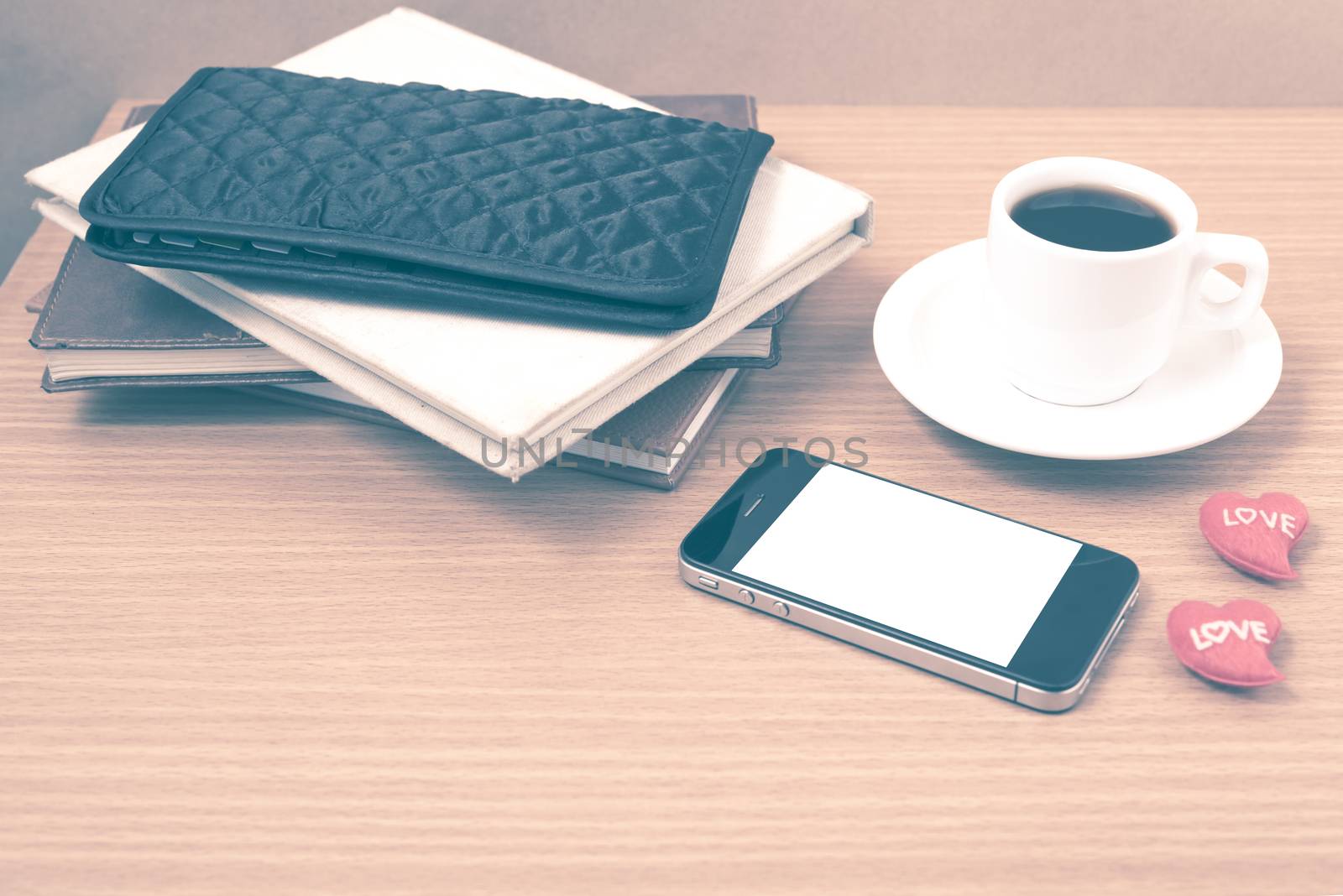 office desk : coffee with phone,heart,stack of book,wallet on wood background vintage style