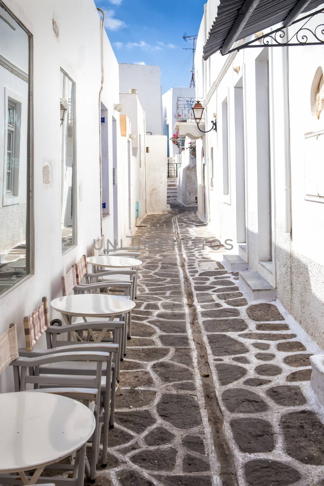 Narrow street with traditional white houses in Parikia, the capital of Paros. Parikia harbour is a major hub for Aegean islands ferries and catamarans.