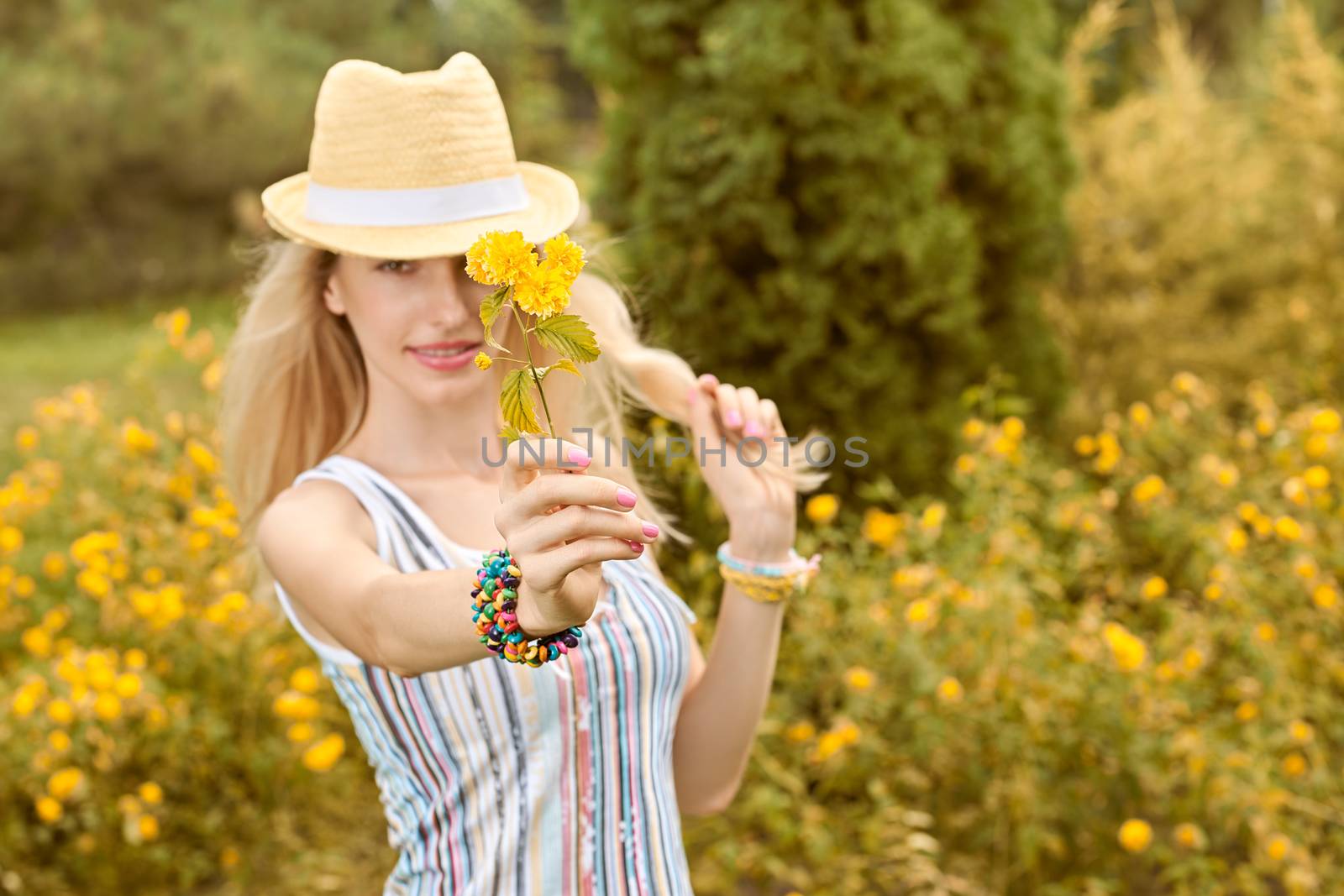 Beauty playful woman relax in summer garden smiling, people, outdoors, bokeh. Attractive happy blonde girl in hat with flower enjoying nature, harmony on meadow, lifestyle. Sunny day, forest,copyspace