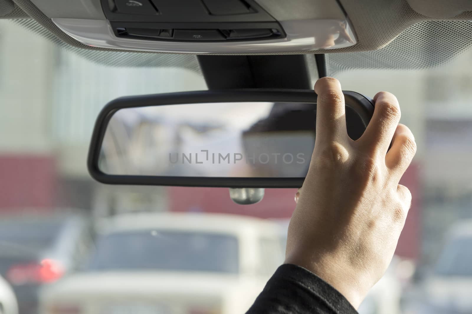 girl adjusts the rearview mirror