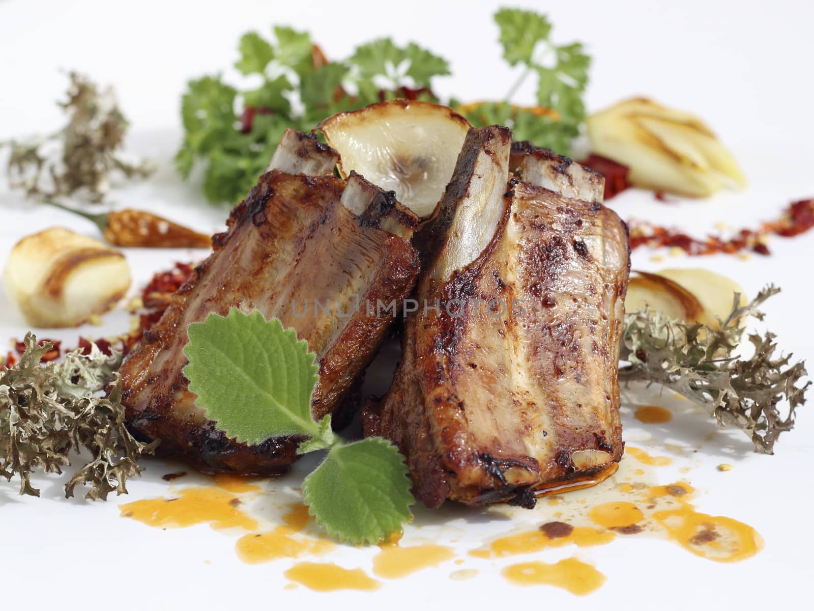 Close up of grilled pork ribs served with fried onions and garlic