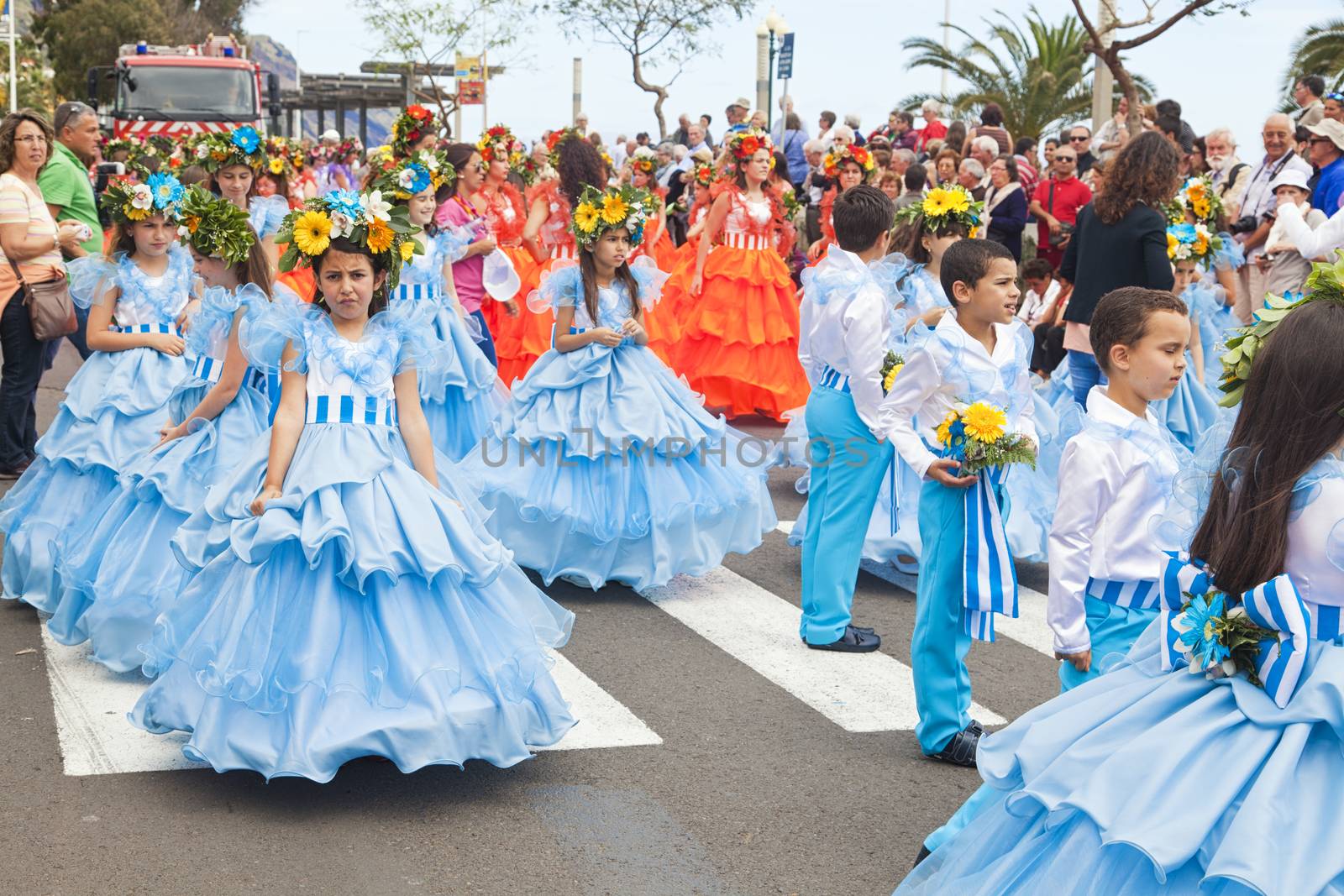 Performers with colorful and elaborate costumes taking part in the Parade of Flower Festival on the Madeira Island, Portugal. by oleandra